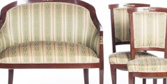 Four chairs and an empire-style sofa.