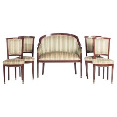 Four chairs and an empire-style sofa.
