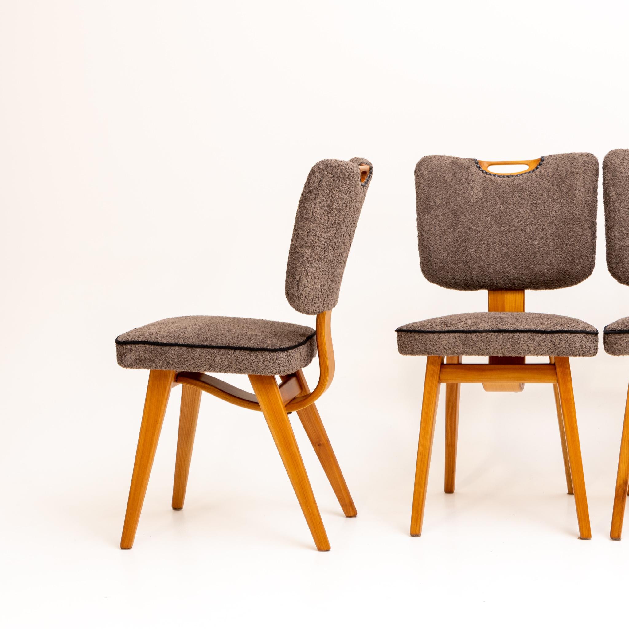 Set of four beech dining chairs with trapezoidal backs. The seats and backrests have been newly upholstered in a dark bouclé fabric.