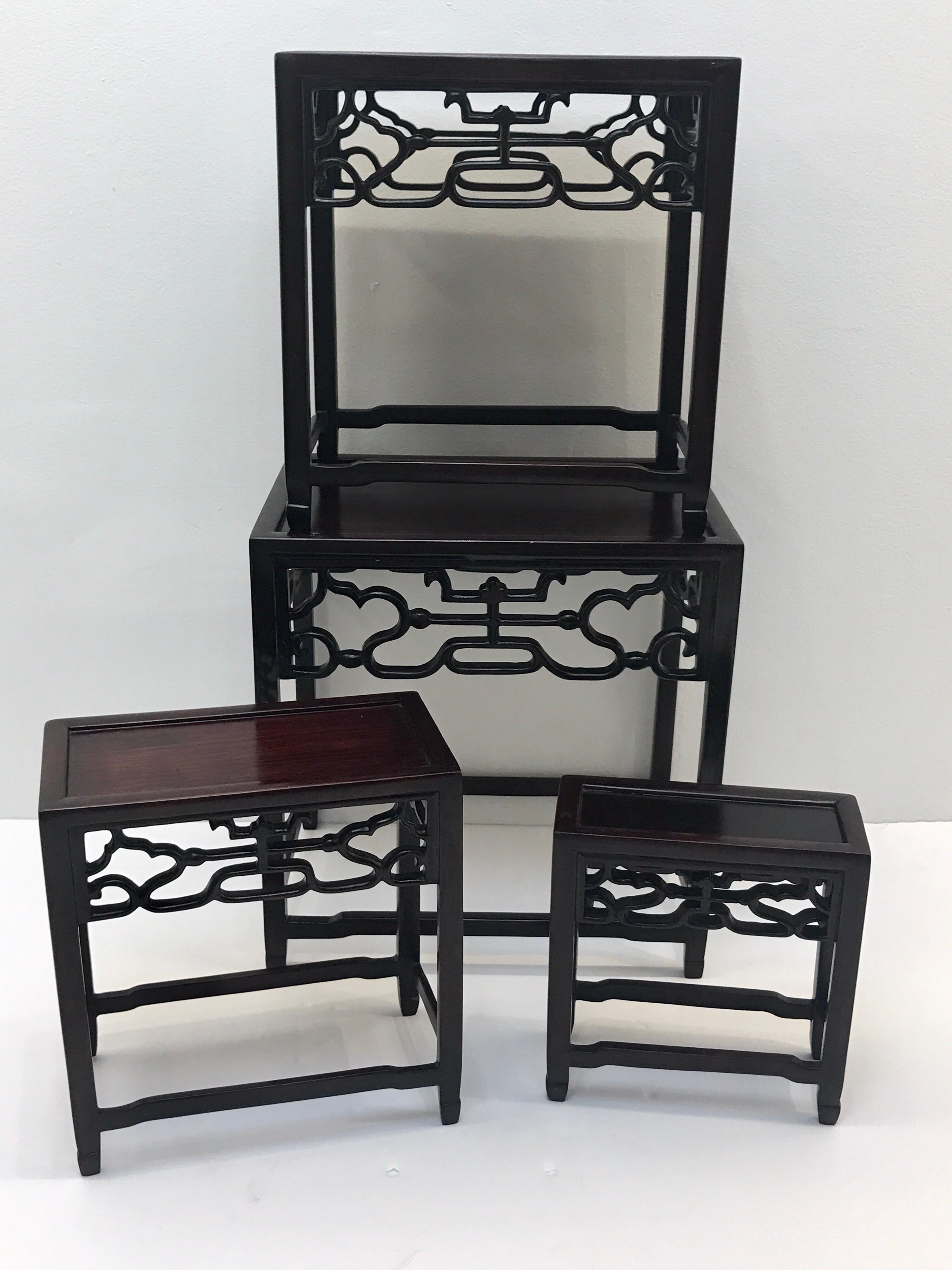 Four Chinese graduating carved hardwood stands, each one of rectangular form with intricate carved friezes, the stands nest for transport.
Measures: 2.5