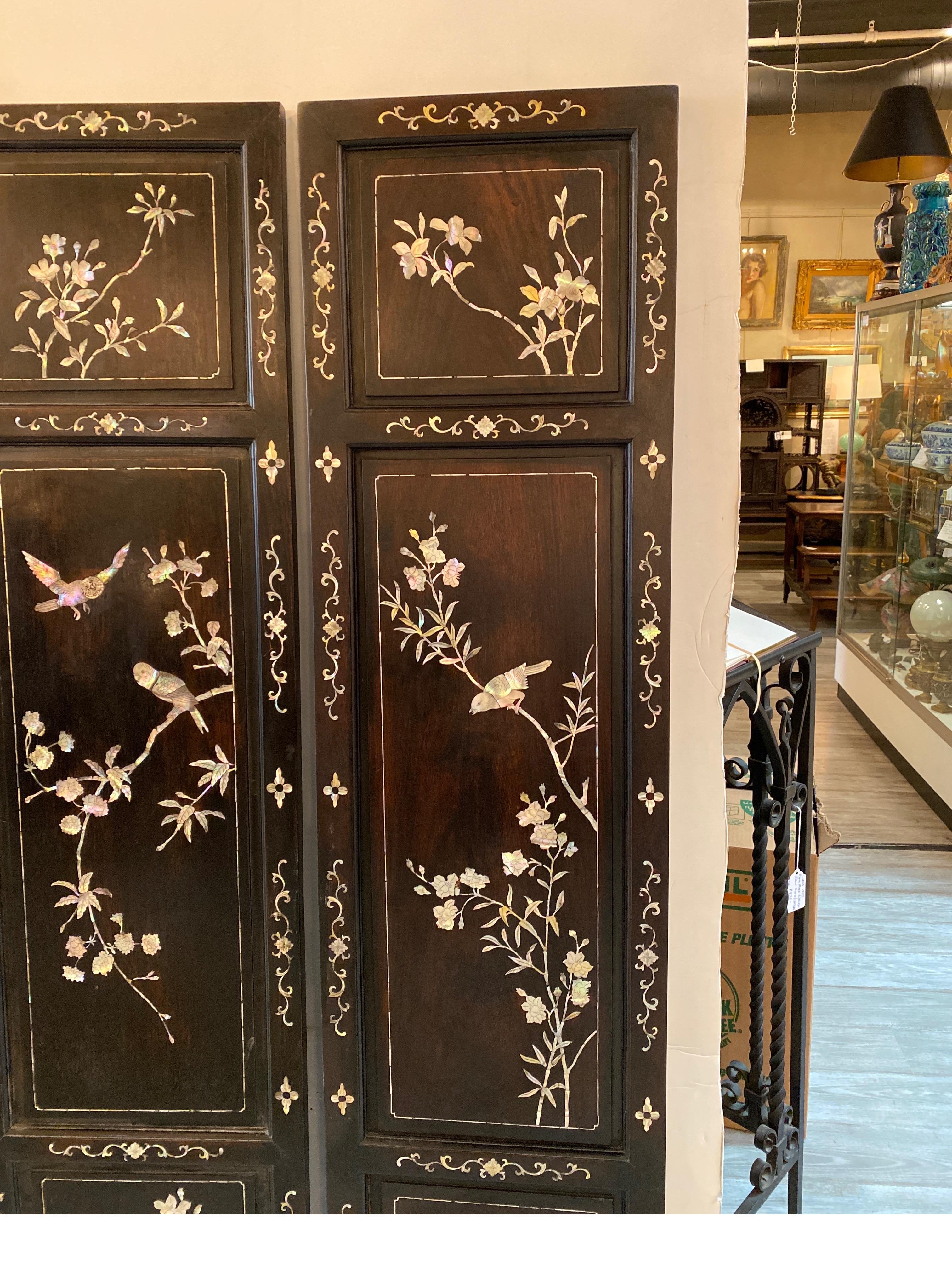 A set of four antique Chinese decorative panes with mother of pear inlay. The panels with floral and branch with various birds hand inlaid into a hardwood panel. The four panels may have been a folding screen but are smoothly finished all along the
