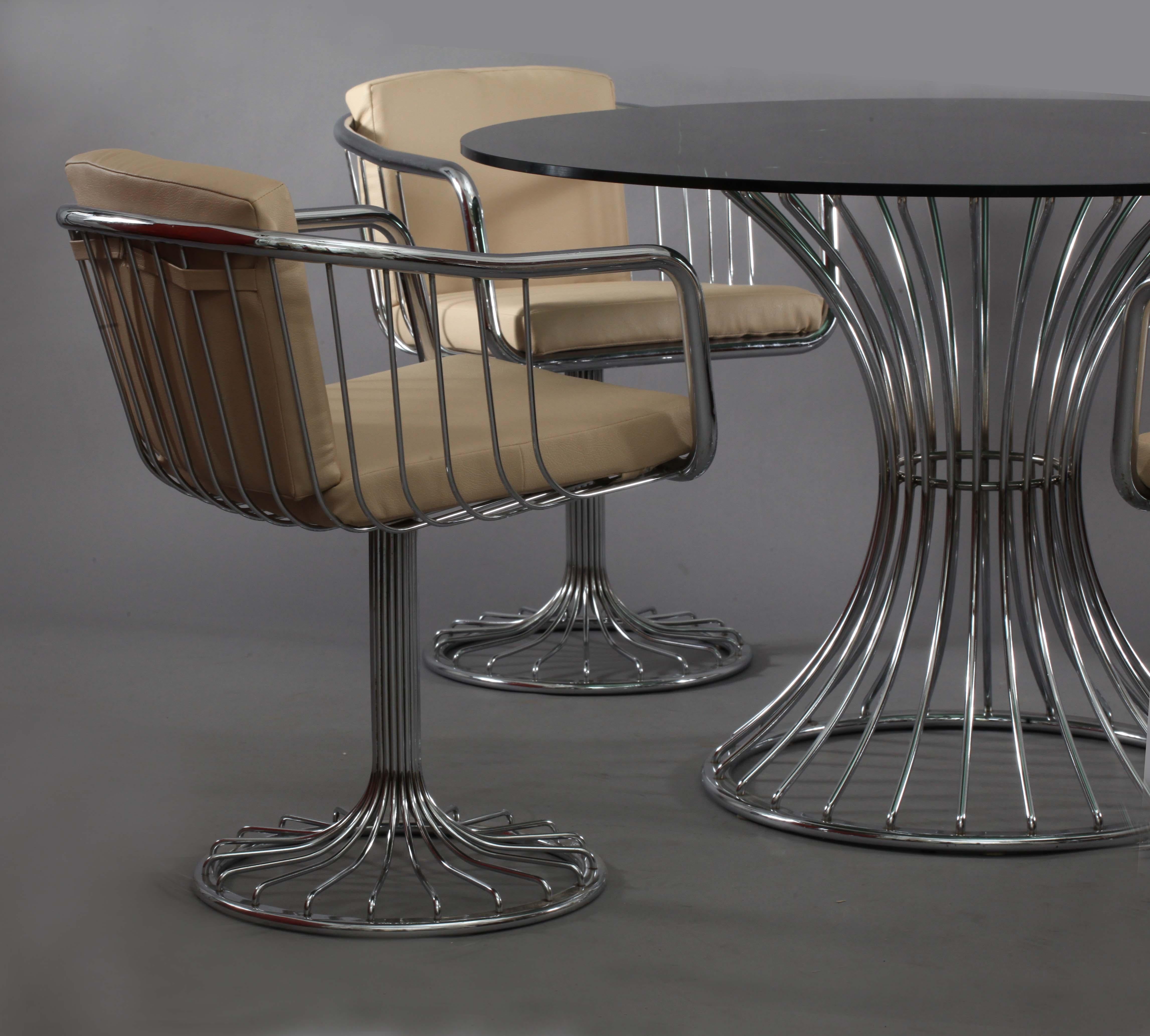 Four chrome armchairs and table
Rinaldi Gastone
Italy 1970
Chrome, leatherette seat,
Smoke glass plate diameter 110cm.