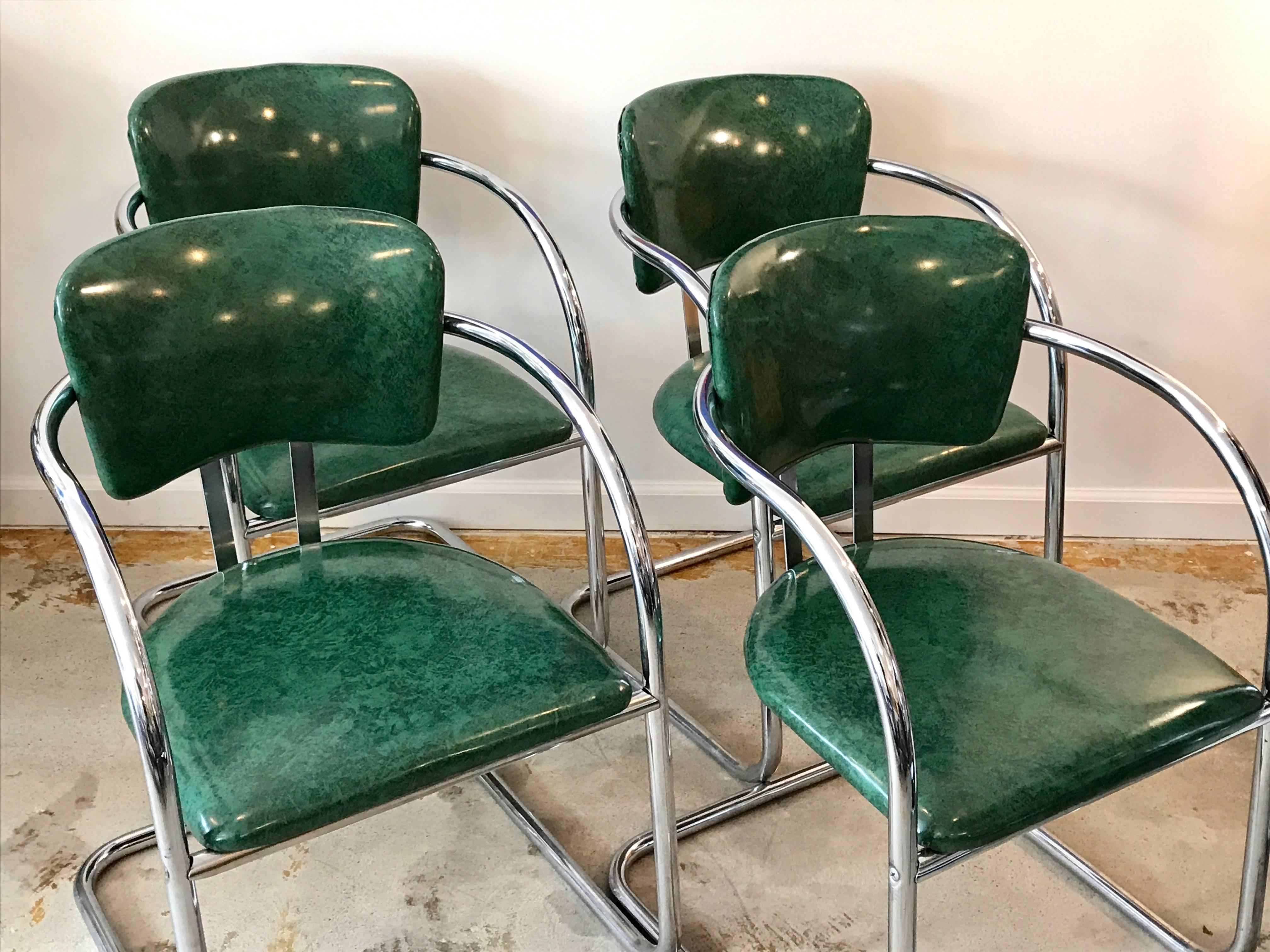 Awesome set of four tubular chrome cantilevered dining armchairs with grass green vinyl padded seats and backs. This Classic 1930's streamline modern design is characteristic of the works by KEM Weber.