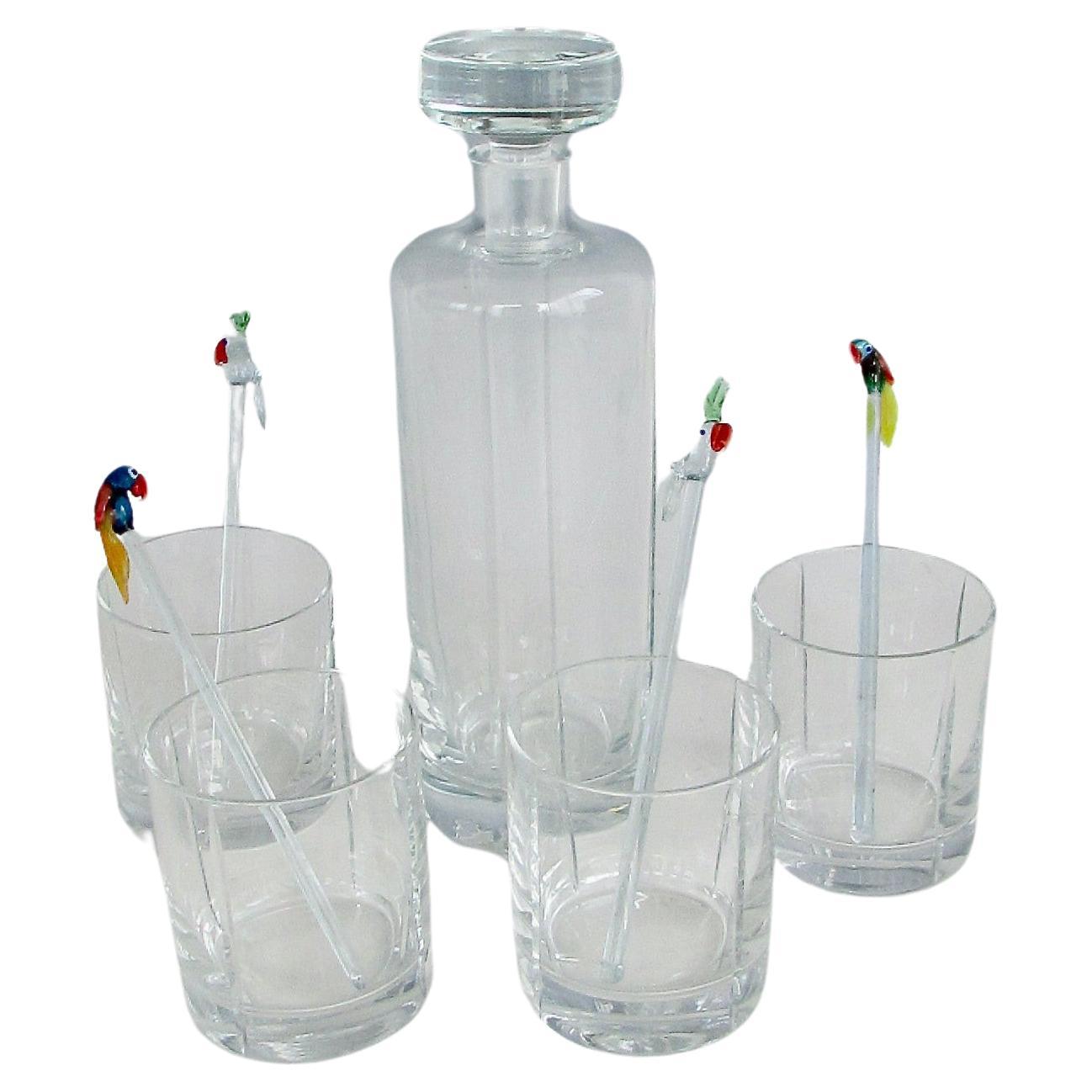 Cuatro  vasos clásicos de whisky con hielo y decantador a juego