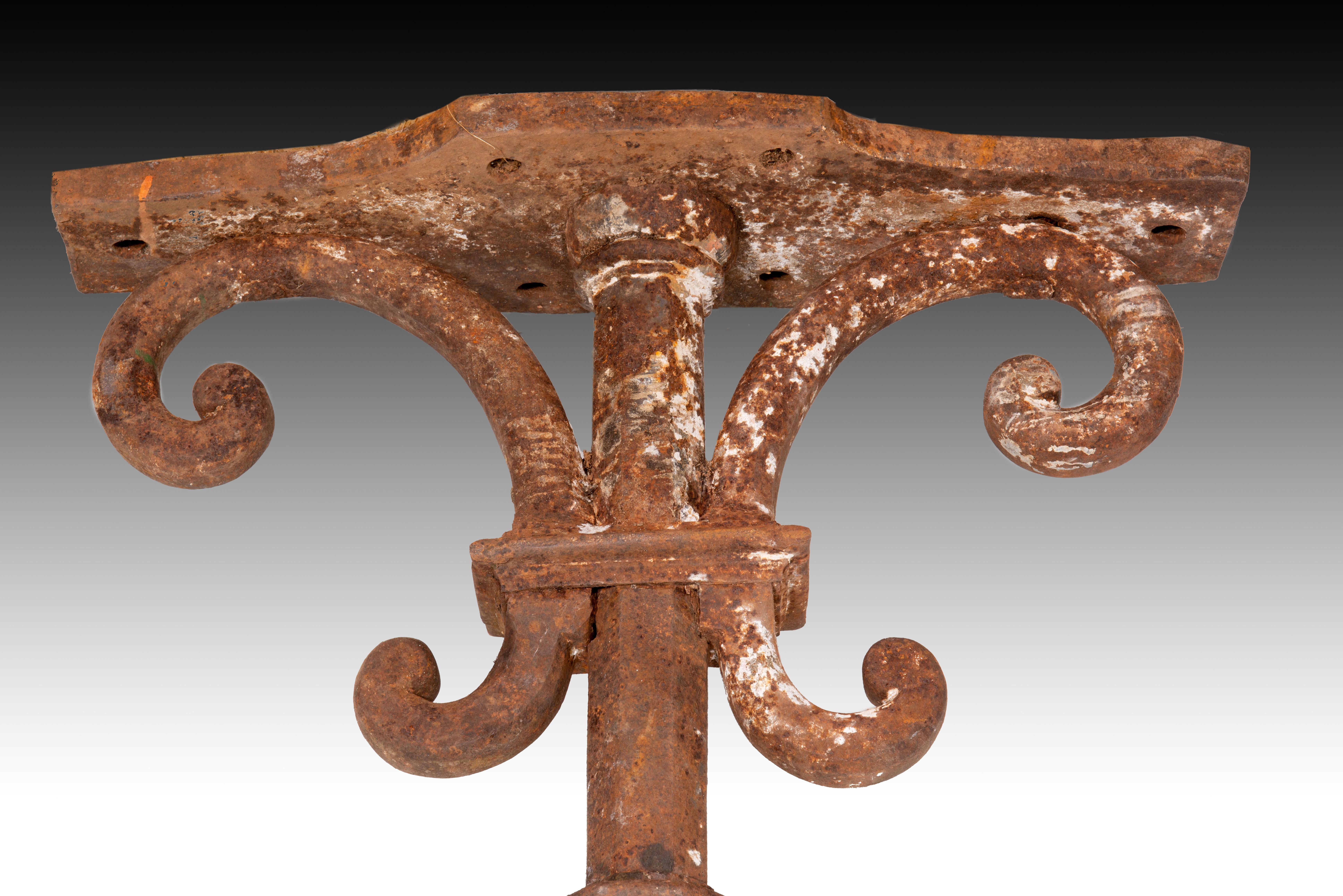 Four columns. Iron. 17th century 
Four iron supports with a polygonal shaft, balustrade shape and upper part with two sections on the sides of the central one ending in volutes and a horizontal part in the same material as the rest. This type of