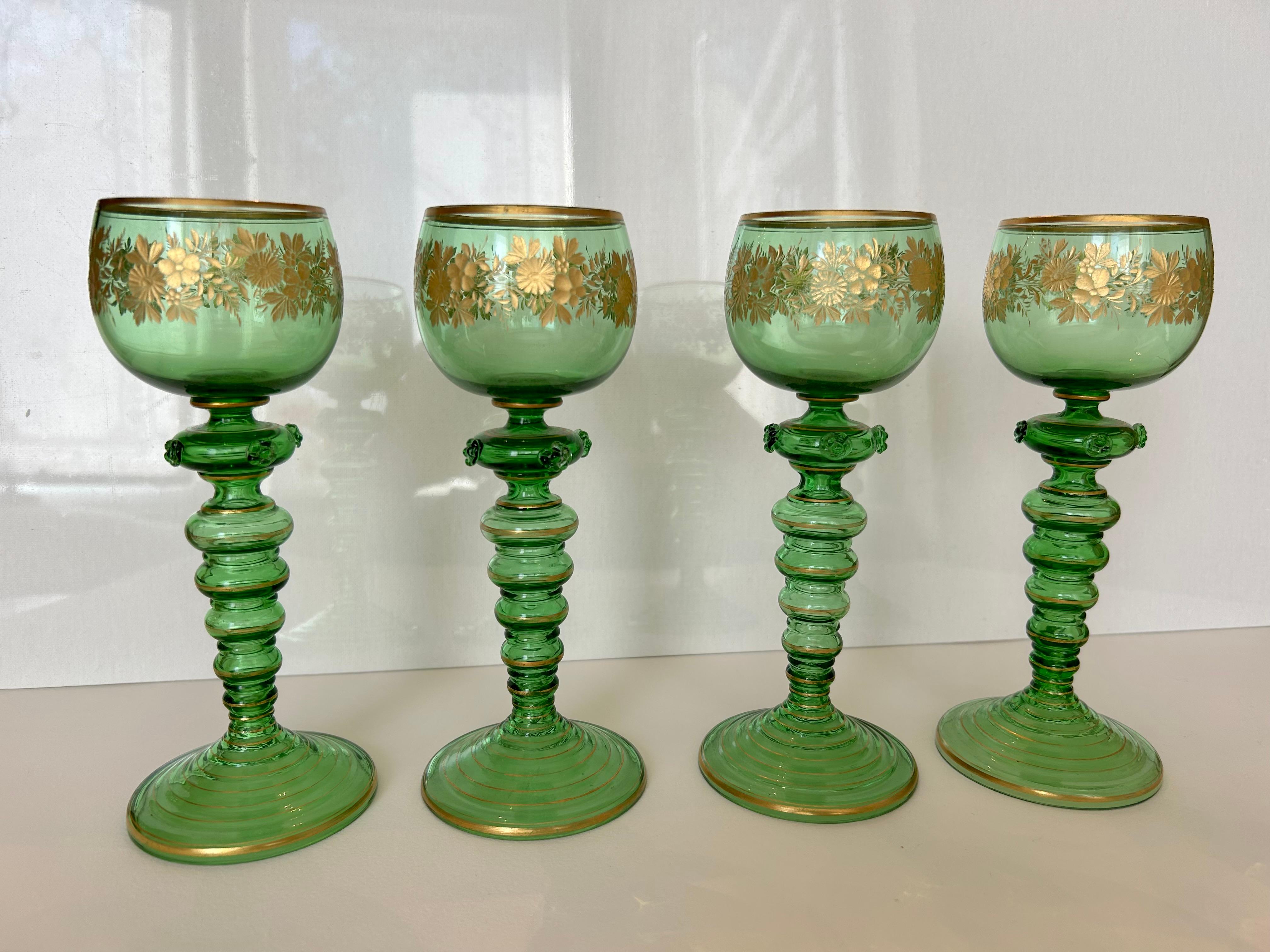 An exquisite set of four Roemer glasses, circa 1900. Each in bright green glass engraved and gilded with scrolling flowers and graduated gold rims. All four in mint condition.
These glasses are probably from the Netherlands, but may also be German