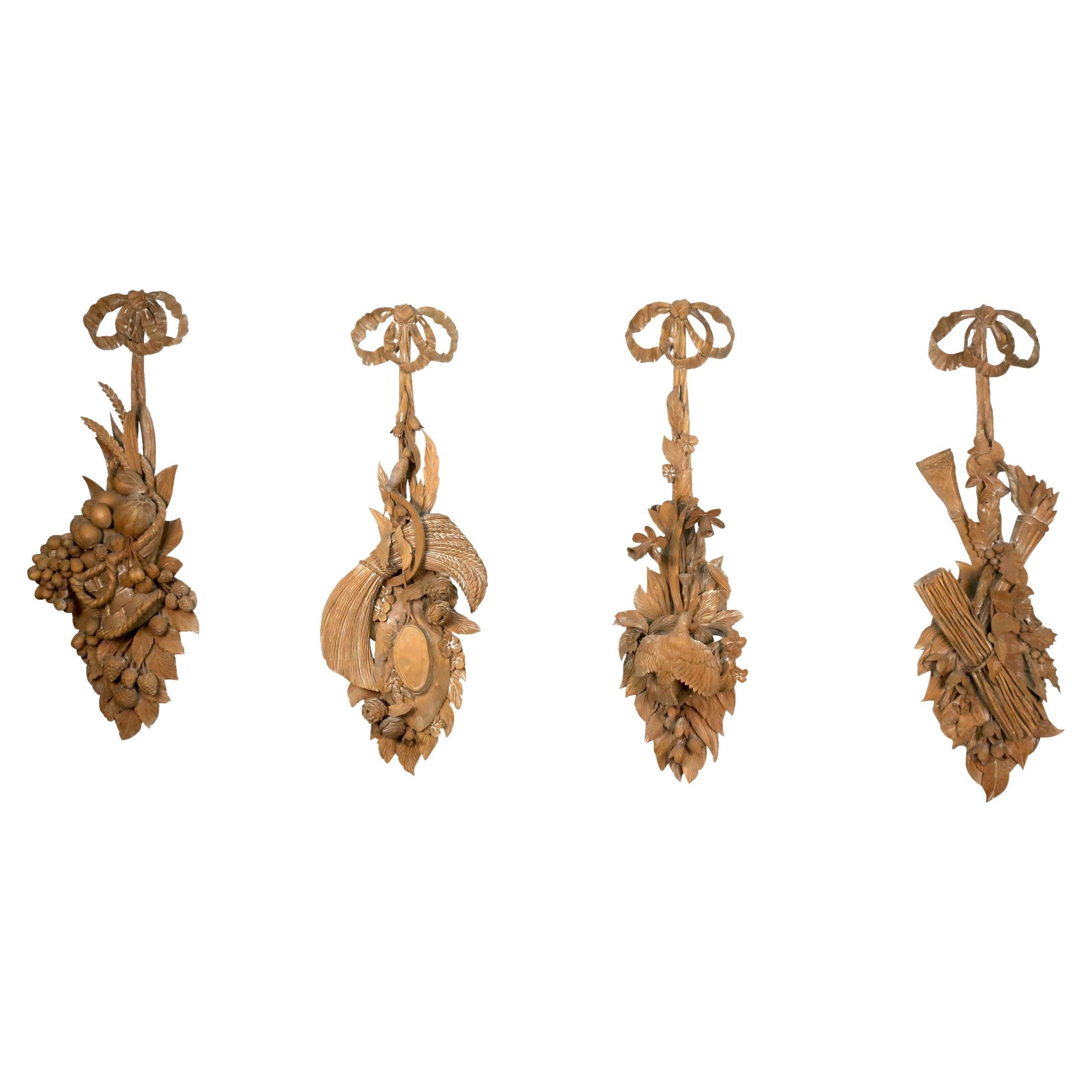 Quatre panneaux en bois sculptés continentaux des « Quatre saisons » avec cintres en forme de ruban