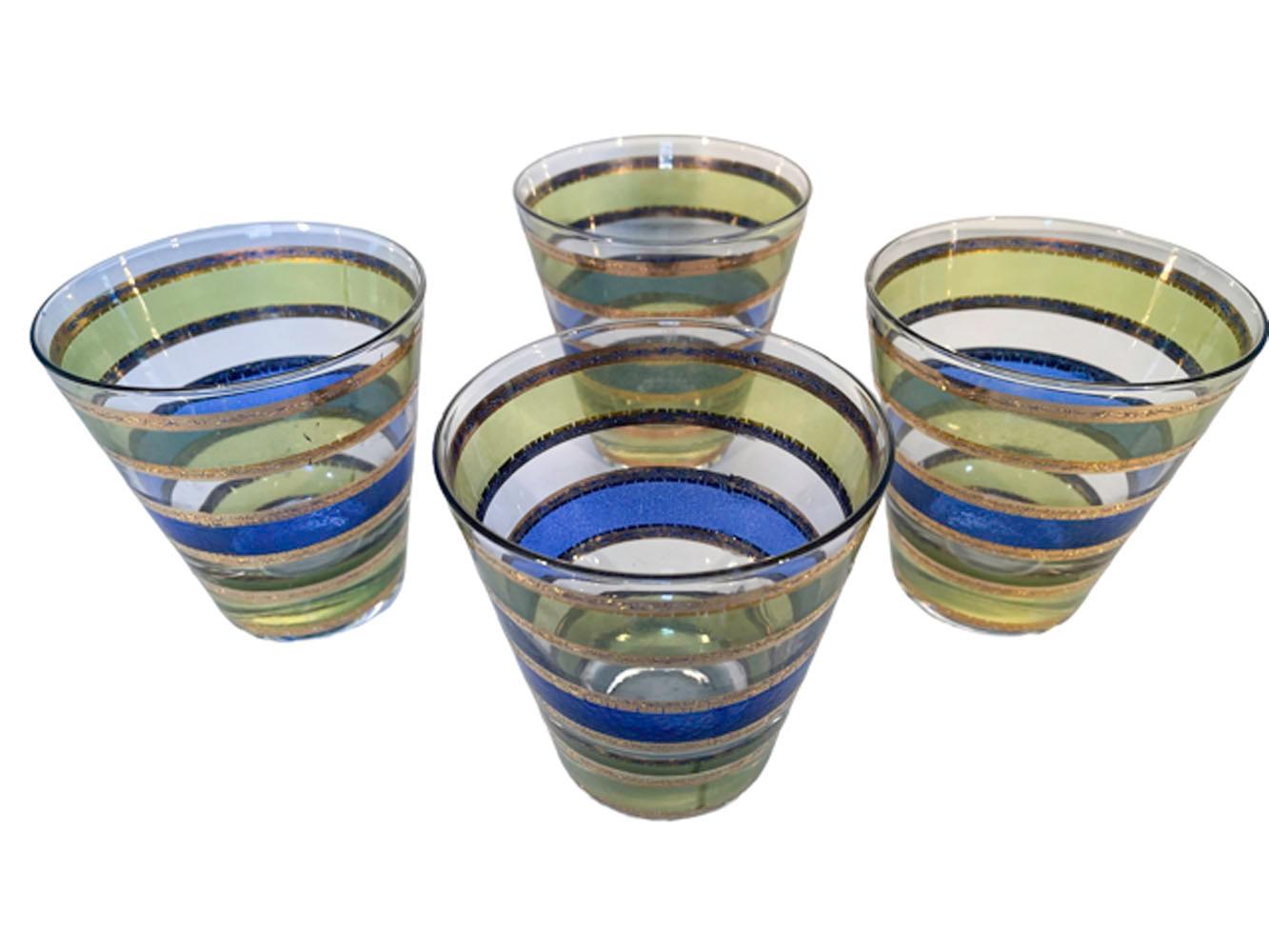 Four vintage double old fashioned glasses by Culver, LTD. in the Rondo pattern. Decorated with a band of translucent blue enamel between bands of translucent green enamel and with the bands having borders of 22k gold with irregular edges and raised