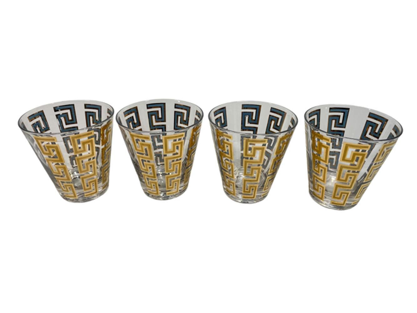 Four Culver, LTD. double old fashioned glasses with tapered sides having vertical Greek Key bands of 22k gold over blue enamel. The gold with satin finish within gloss on the exterior with the blue visible only on the interior with gold border.