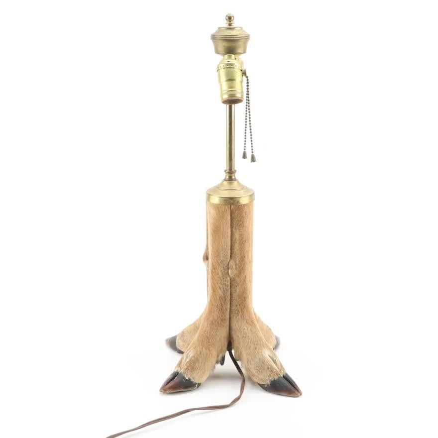 Lampe de table en sabot de cerf taxidermisé d'une qualité exceptionnelle. Quatre sabots, chacun provenant du même cerf, et de la vraie fourrure de cerf recouvrent la base. Éclairage à double prise. Accepte les ampoules à culot E26 standard. Tirer