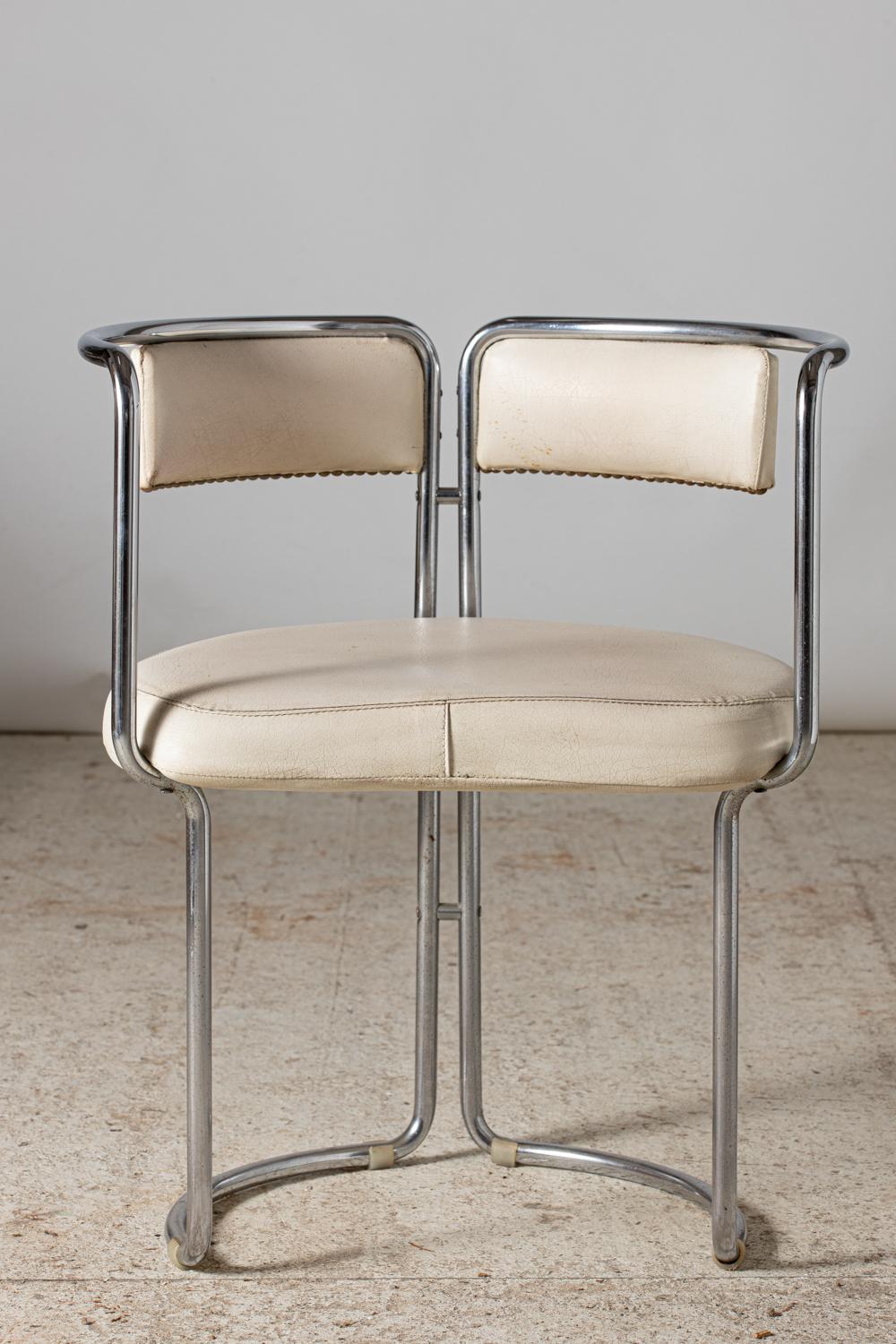 Set of four round dining room armchairs in chrome and original upholstery in off-white leatherette.