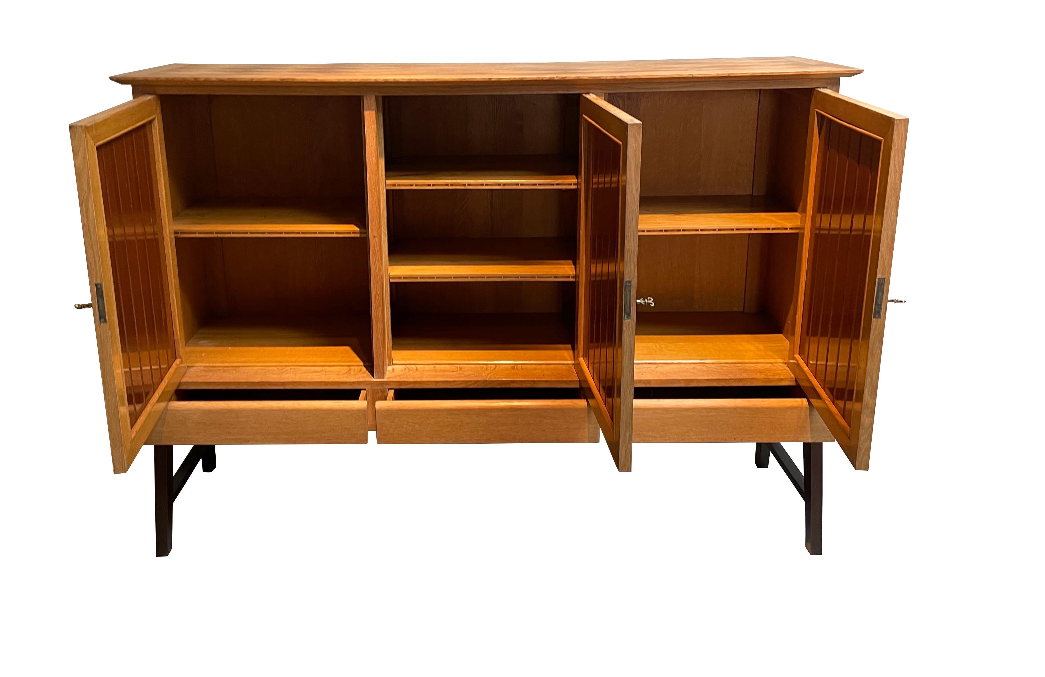 1950s' French Joseph - Andre Motte designed credenza.
Four fluted wooden doors in darker contrasting stained wood.
Credenza sits on angled footed base.
Decorative parquet top.
Three exterior drawers and four interior shelves.
Arriving November.