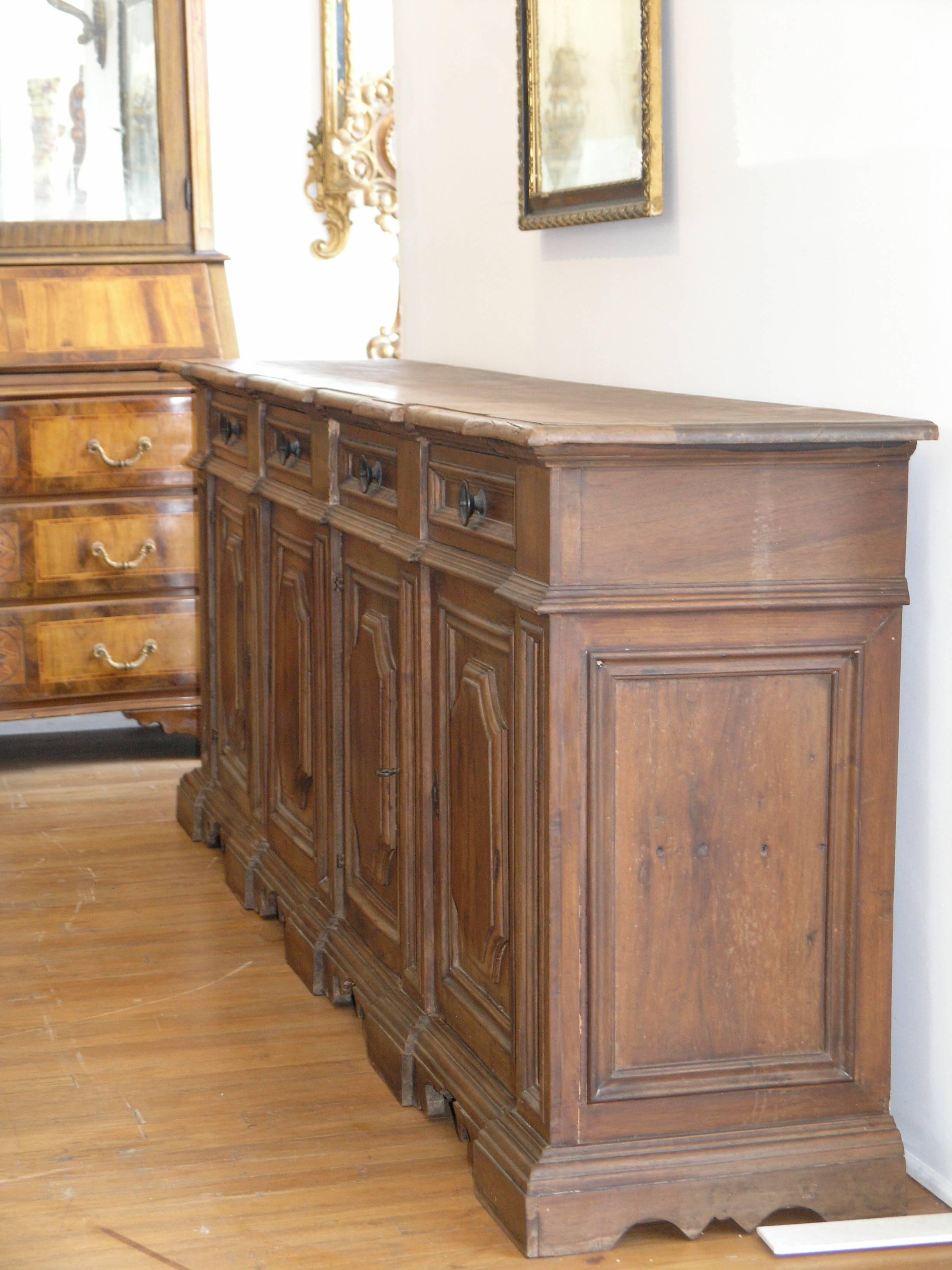 Rectangular top with molded edge over four drawers, above four-paneled doors raised on bracket feet.