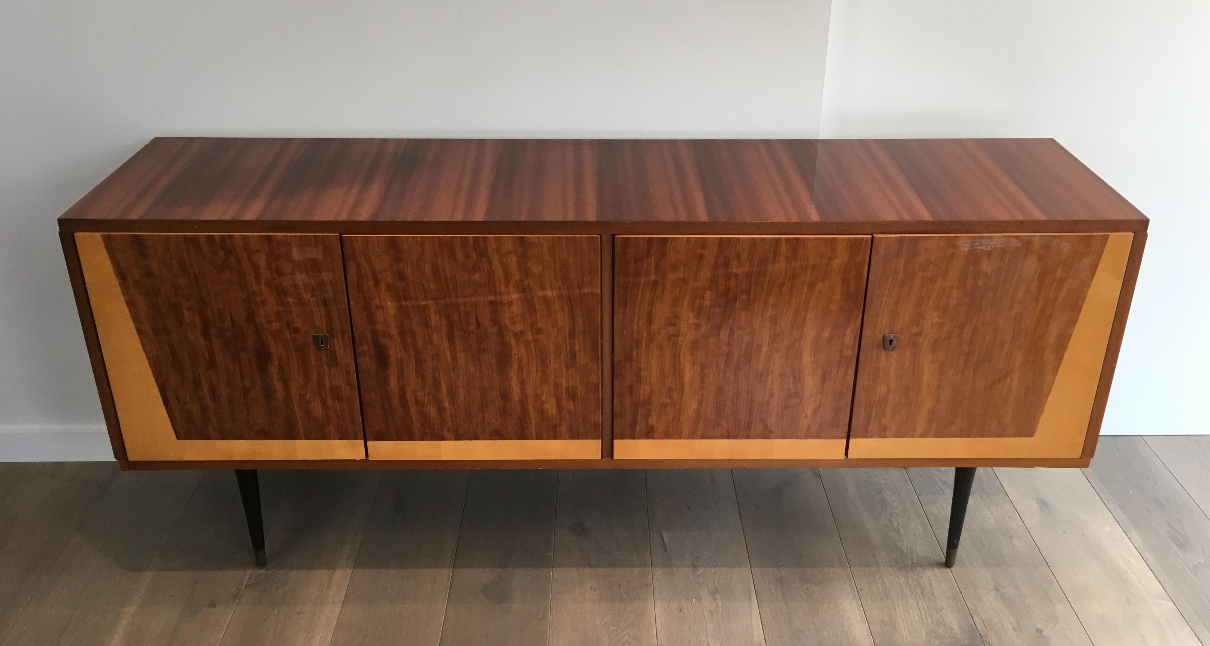 This very nice sideboard is made of Sapelli mahogany and sicamore wood on a black lacquered wood base with brass elements. This very elegant sideboard has 4 doors opening on a sicamore wood inside. This is an Italian design, circa 1960.