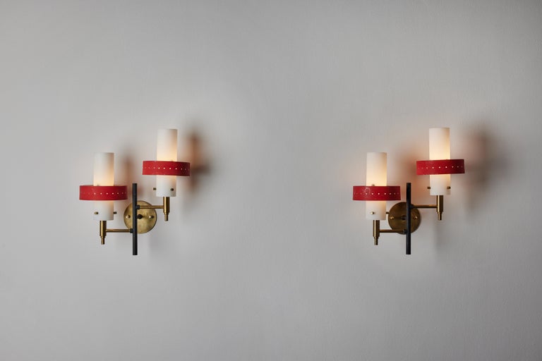 Four double arm sconces by Stilnovo. Manufactured in Italy, circa 1950's. Brushed satin glass diffusers, painted metal armature, custom brass backplates. Manufactured in Italy, circa 1950's. Wired for U.S. standards. We recommend two E14 60w maximum