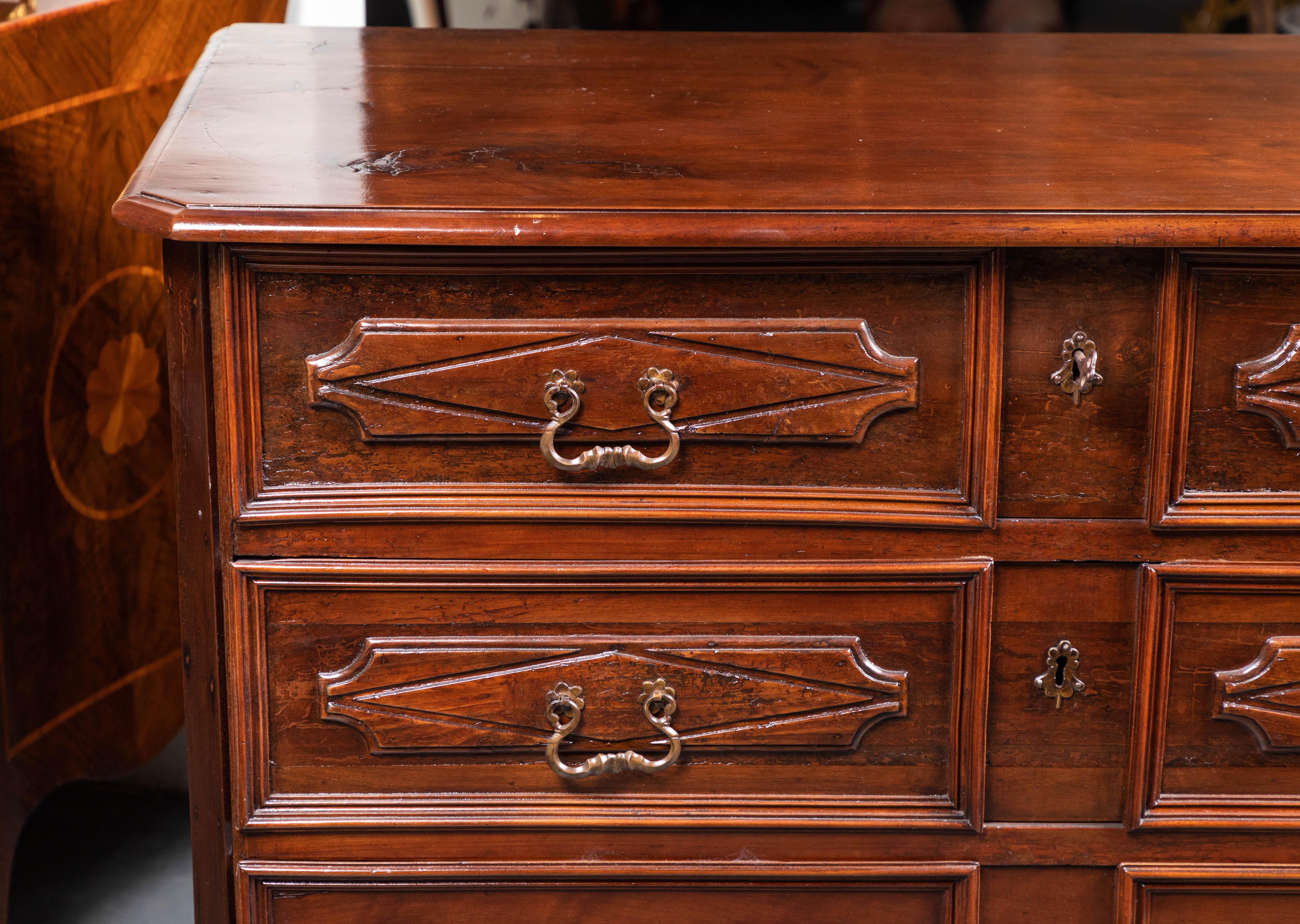A fine, hand carved, clipped corner, circa 1820, walnut commode with four, raised panel drawers, and raised panel sides.