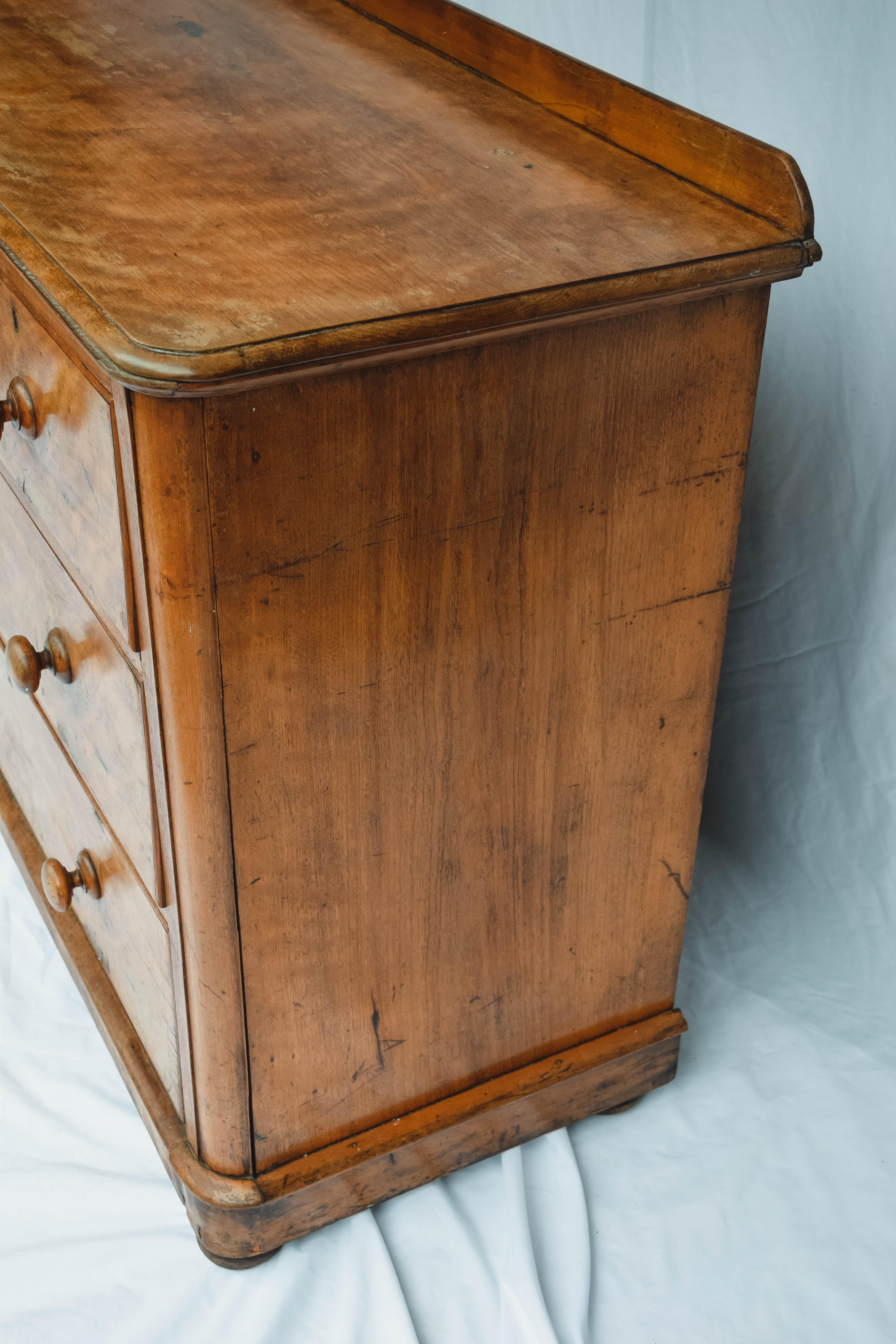 This beautiful 19th century English Pine four drawer chest is constructed with two drawer over two drawer configuration and has a beveled edge around the top, simple round knobs and key holes. The bottom of the piece is molded and stands on four bun