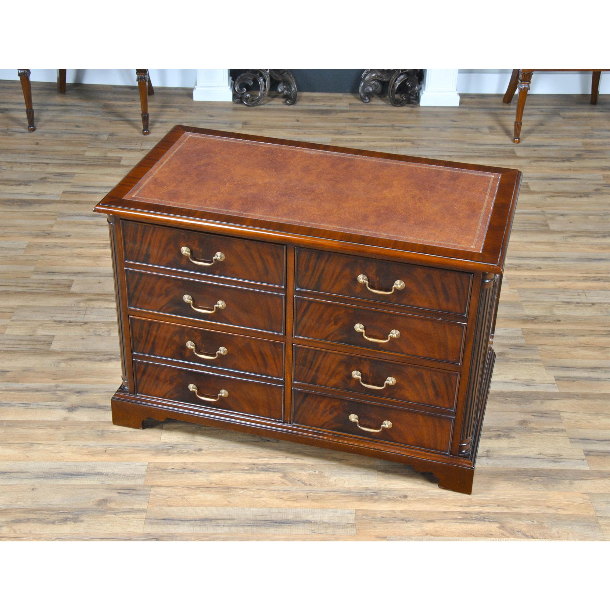A highly functional and decorative piece this Four Drawer File cabinet is made with figured mahogany. The top of the cabinet is covered in a full grain brown leather panel which is attractively tooled around the edge with gold tooling. In the front