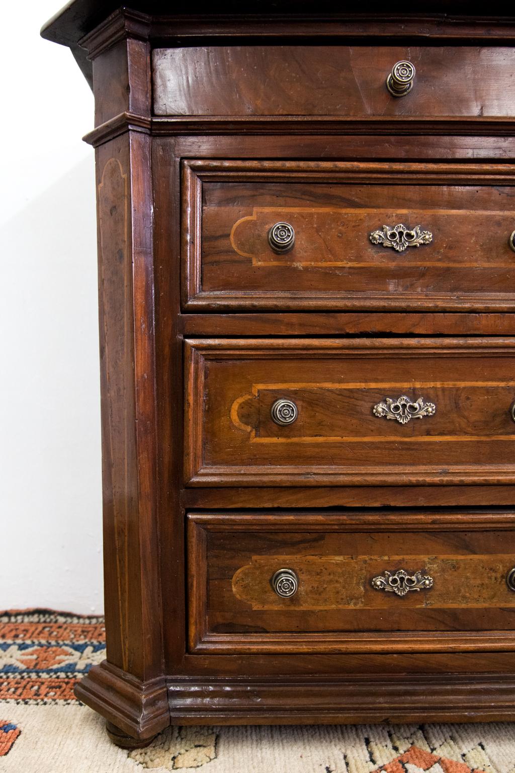 Four-drawer inlaid French chest, the chamfered sides inlaid with birds eye maple and boxwood. The drawers have deep molding as well as boxwood and burled walnut panels. The top is mahogany and it rests on small button feet.





  