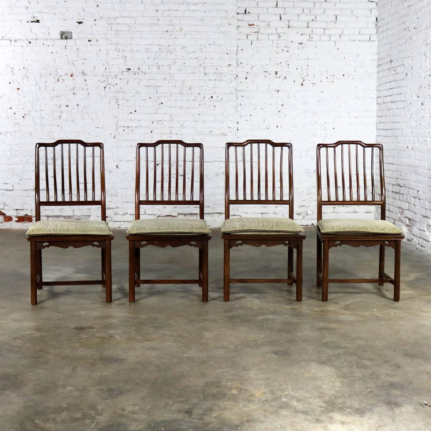 Handsome set of four Drexel Heritage Chinoiserie Ming style spindle back dining chairs with semi-loose cushion seats which are upholstered in a black and greige stripe chenille fabric. They are in wonderful condition with age appropriate wear and