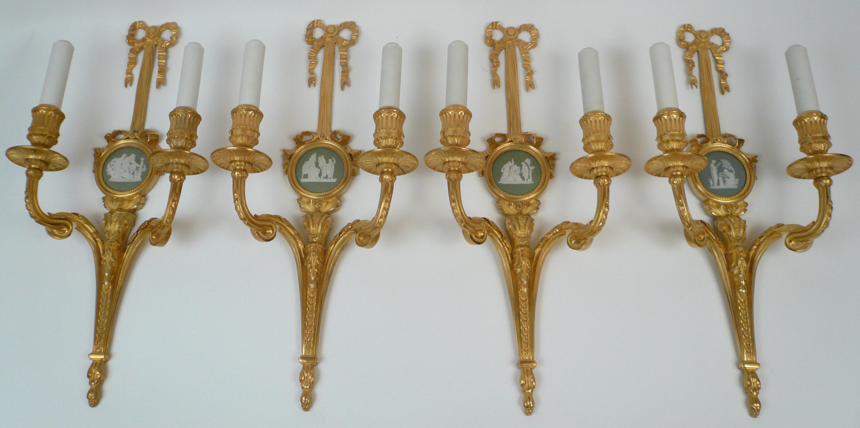 These beautiful sconces are of the finest quality, and feature Classical motifs including bowknots and acanthus leaves. They are mounted with sage green Wedgwood jasperware plaques.