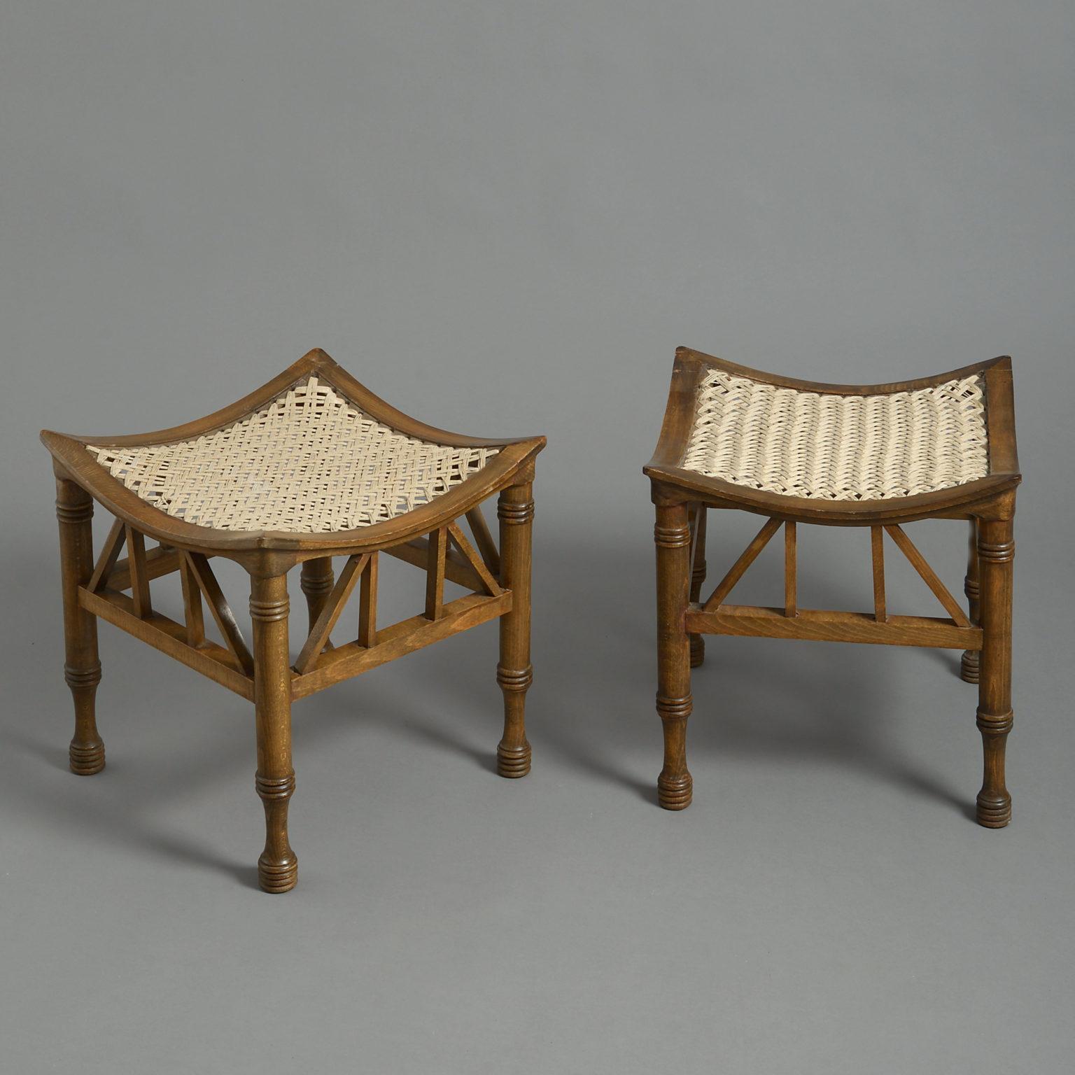 Four early 20th century Thebes stools, attributed to Liberty & Co, each having turned legs between strutted friezes, all supporting concave rope work seats.

These stools are attributed to Liberty & Co. Liberty’s patented the Thebes stool design