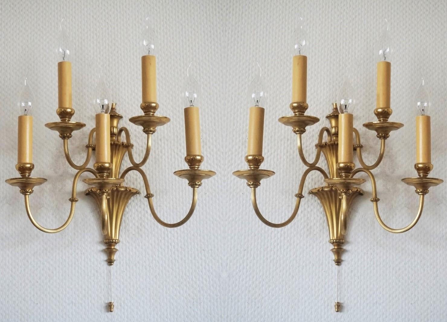 Set of four Victorian style gilt brass wall sconces with five scrolling arms and a fluted conical base, England, late 19th century. The sconces have been electrified and refinished to its original shine.
Five E14 candelabra light bulb holders with