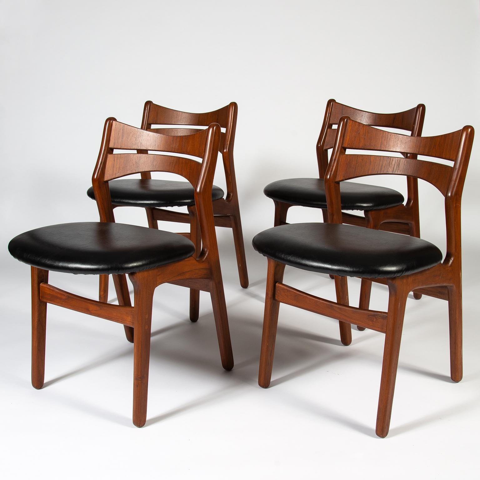 Set of four dining chairs designed by Erik Buck and manufactured by Christiansen Møbelfabrik. The chairs have a beautiful sculptural solid teak frame, distinctive of the Danish modern style, with the seat pad upholstered in a hard wearing black