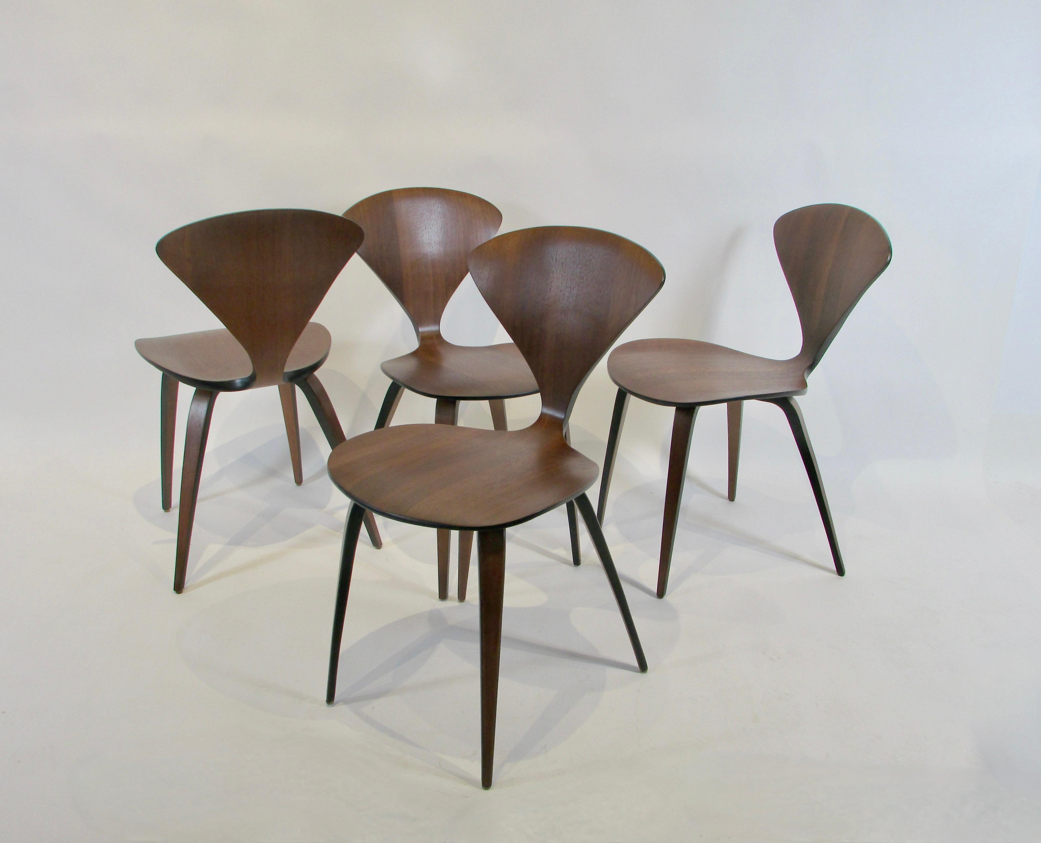 Nicely refinished set of four first generation Norman Cherner dining chairs . Designed by Cherner in the early 1960s , produced by Plycraft . One or two chairs retain the Plycraft label .
 A pioneer both in molded plywood and prefab housing, Norman