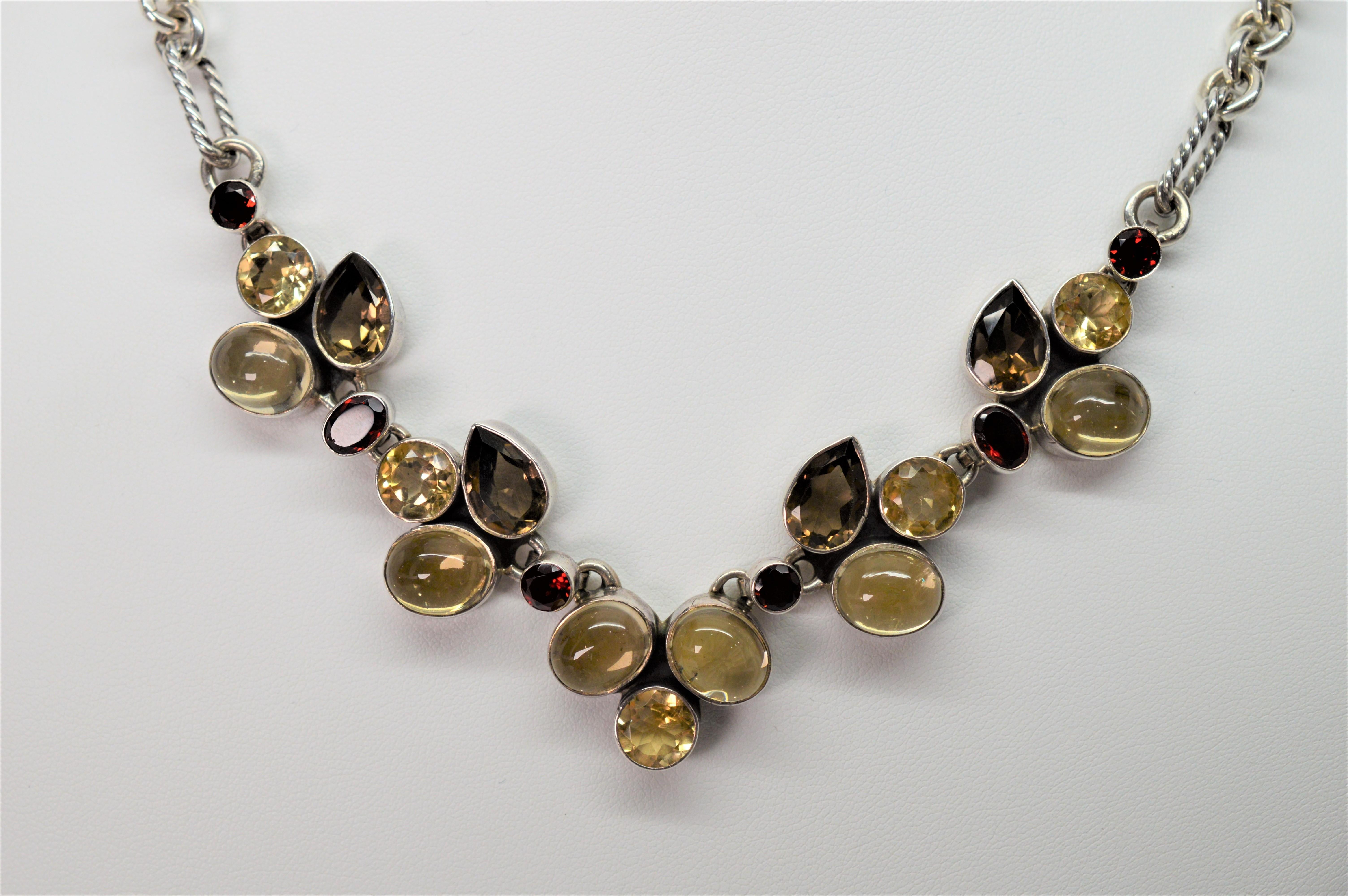 Warm tones of smokey topaz, garnet, citrine and white quartz, all bezel set in sterling silver, create a colorful and striking floral patterned display spanning five inches across the front placket of this vintage statement necklace.  Great with a
