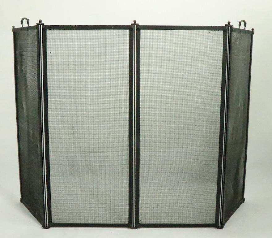 Nicely crafted heavy gage folding fire screen having for panels each 13 W x 30 H inches. The two outer panels have handles making their total H 31.5 inches. Because the screen is in hinged sections, it is adjustable in width, making it easier to