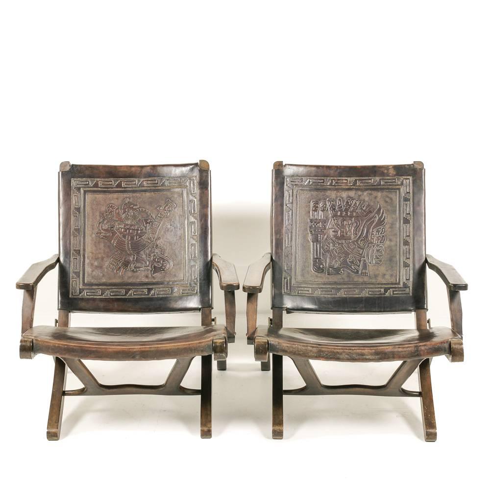 An unusual set of four Peruvian tooled-leather folding armchairs, low-slung and comfortable, the thick full-grain leather embossed with various mythical characters (each chair with a different motif), circa 1960-1970.



 