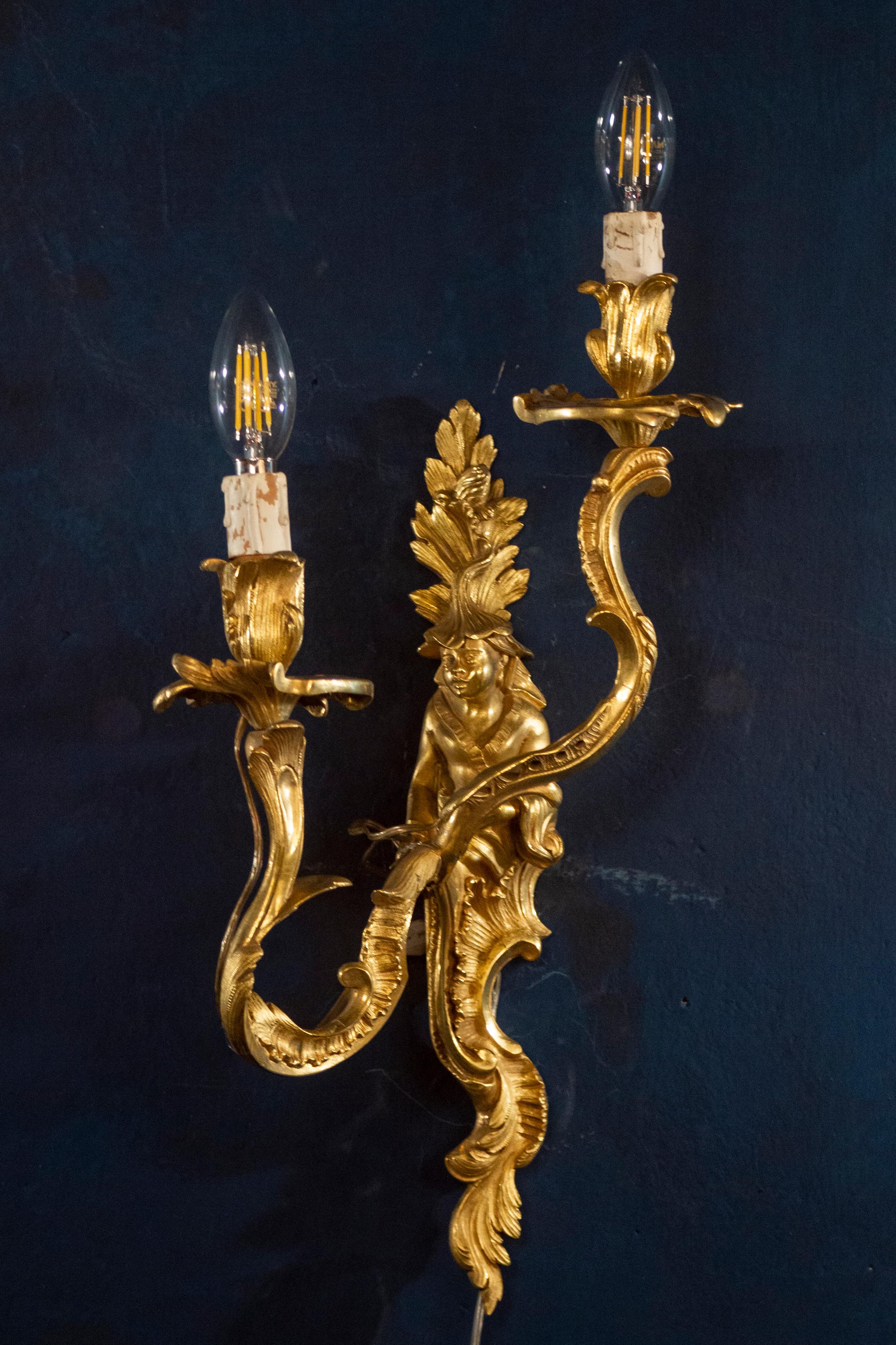 Un bel ensemble de quatre appliques à deux lumières en bronze doré Louis XV du 18ème siècle, chacune avec des figures chinoises finement ciselées, masculines ou féminines. Les bras à enroulement avec des feuilles d'acanthe se terminent par une