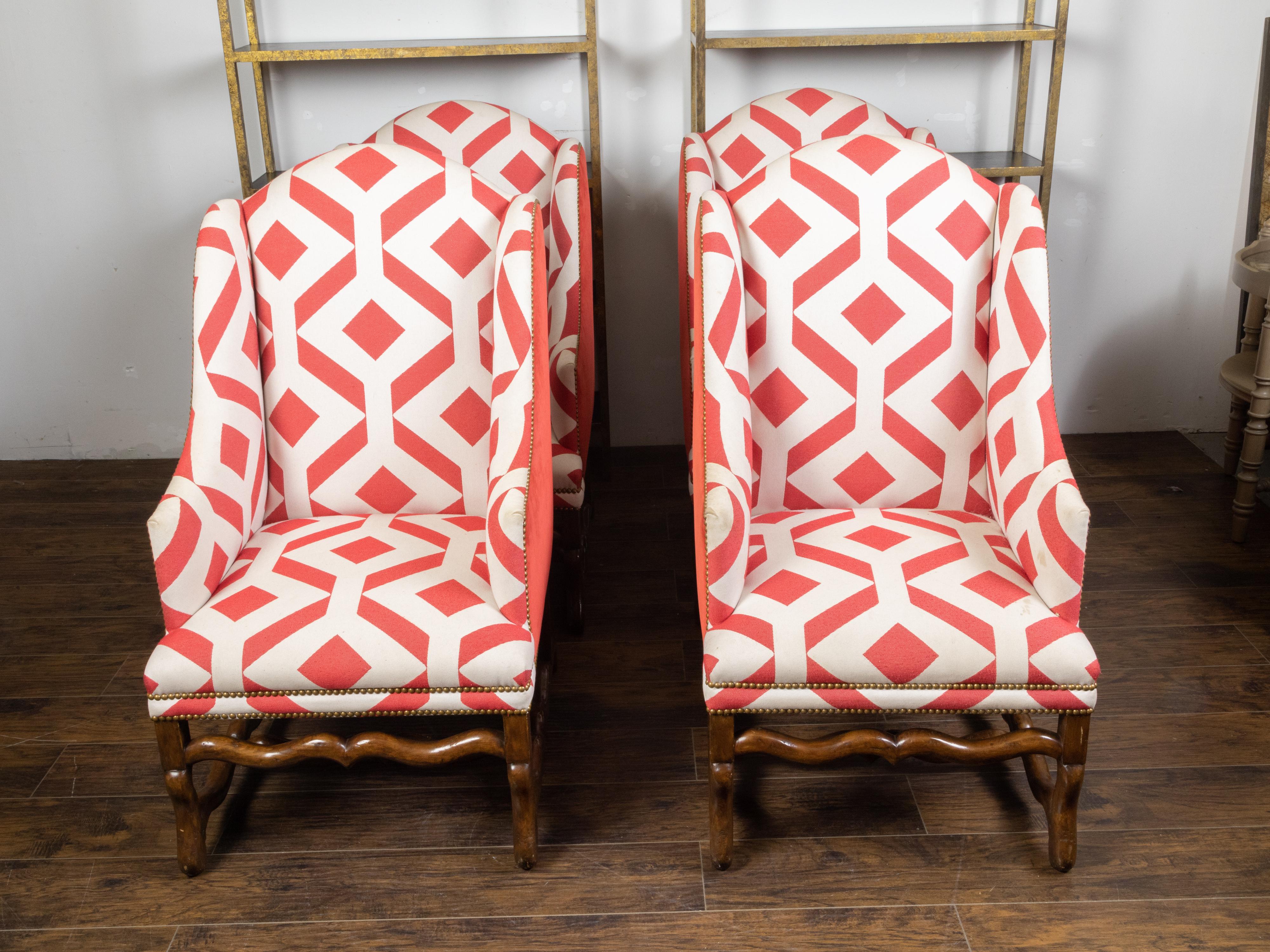 Four French wingback chairs from the early 20th century, with os de mouton bases and red and white geometric upholstery. Created in France during the first quarter of the 20th century, each of this set of four armchairs features a wingback offering