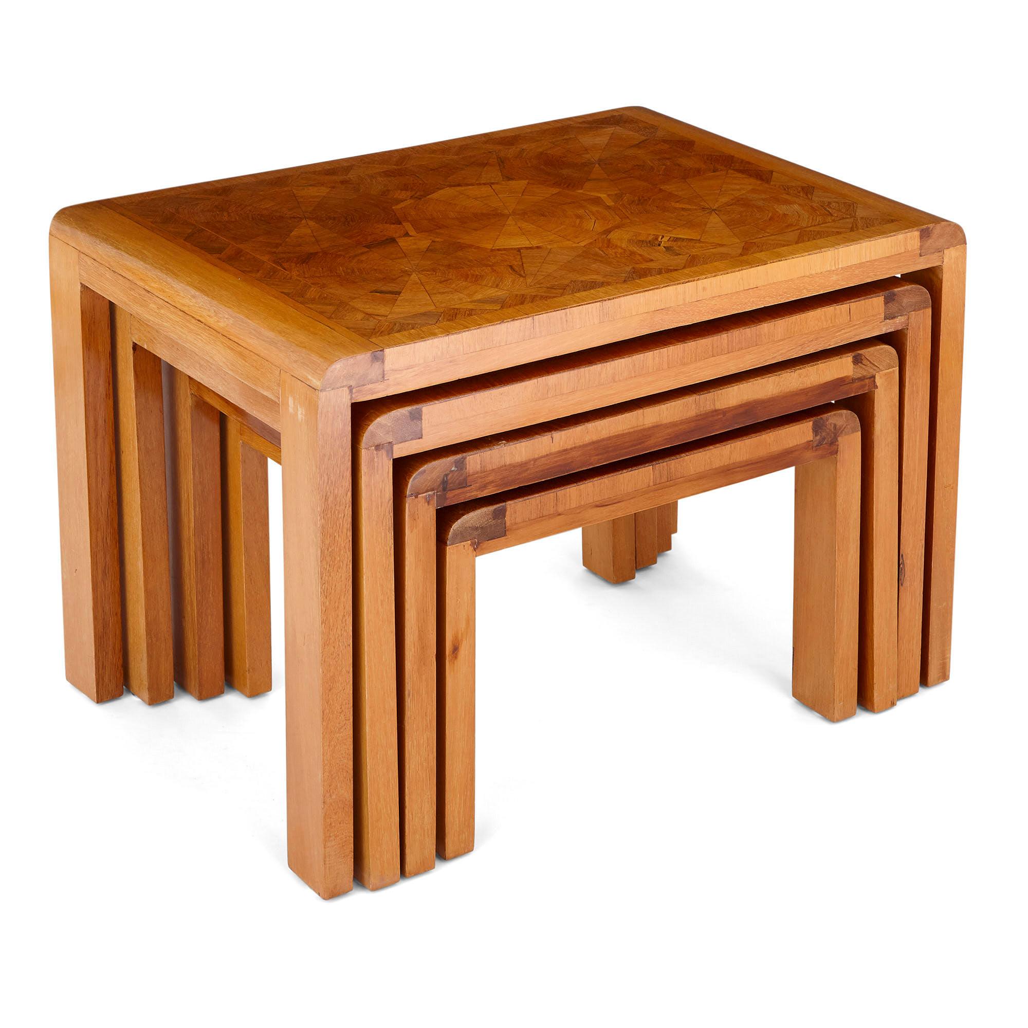 This set contains four nesting side tables. Each table is designed simply and unpretentiously, having clean lines throughout. The top of each table is inset with Art Deco parquetry woodwork, wrought into geometrical forms (primarily octagons and