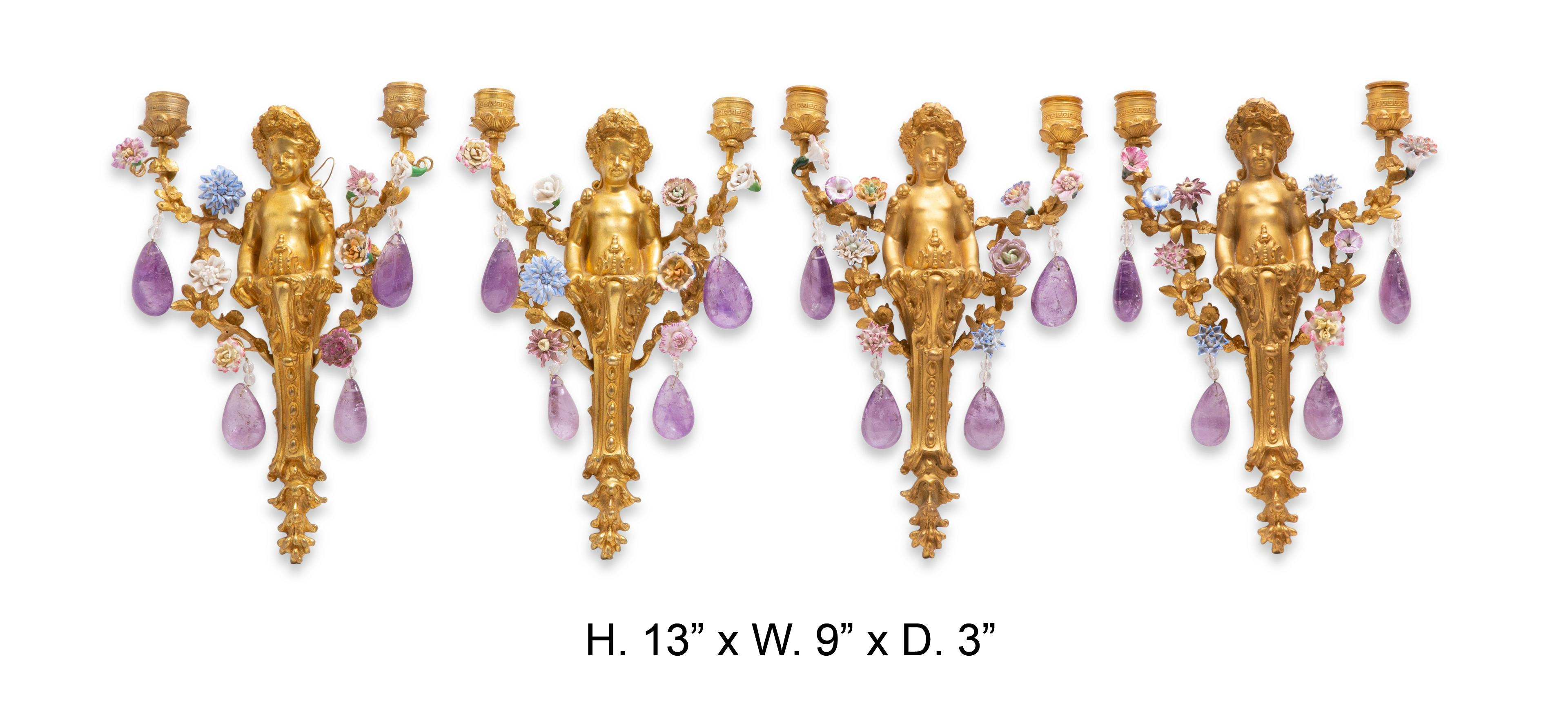 Exquisite set of four French Amethyst Quartz figural ormolu two light sconces with porcelain flowers.
19th century. 

All centered by a gilt bronze putti, issuing two scrolling arms decorated in a floral motif, terminating in a pedal drip pan and