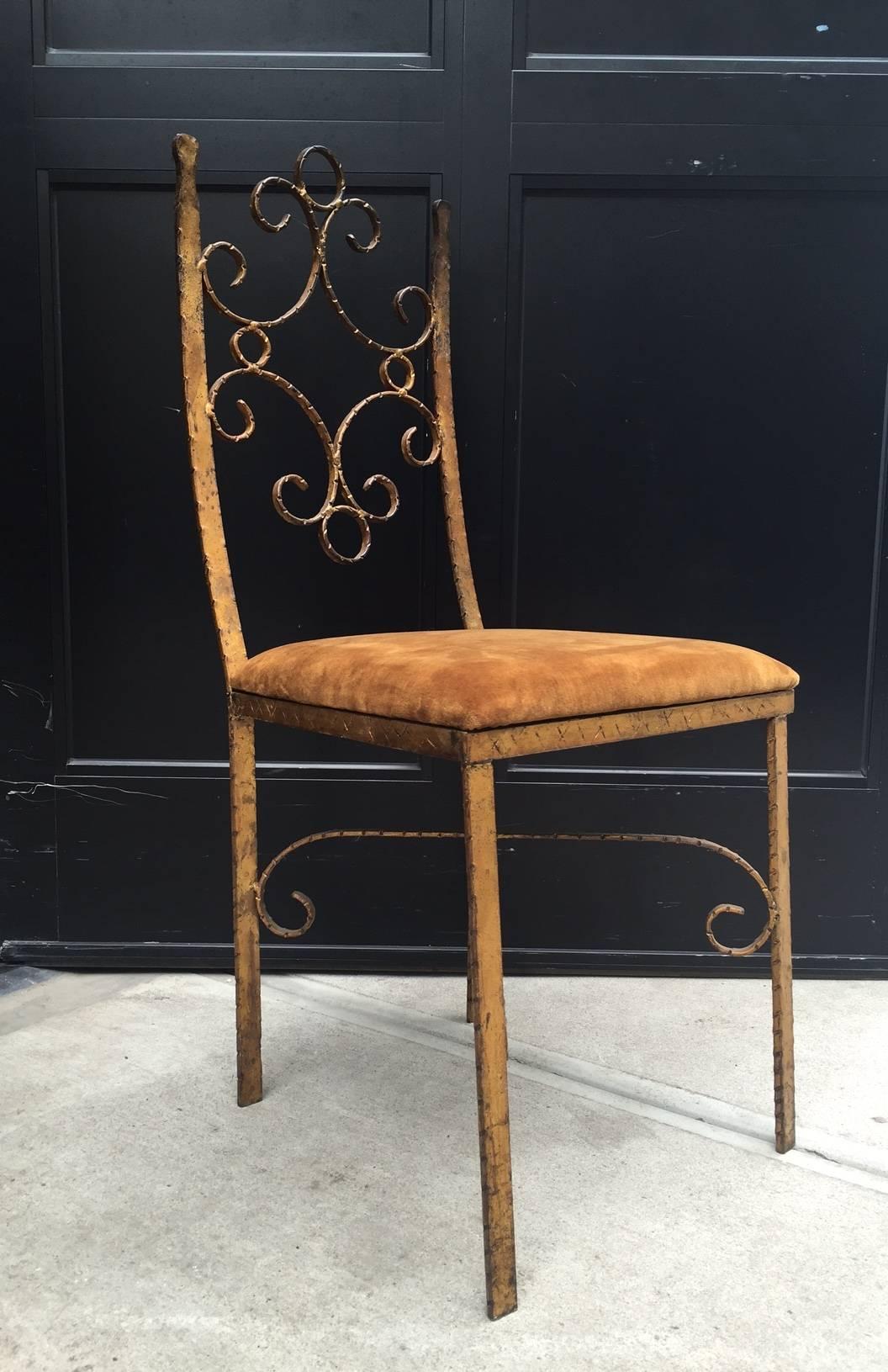 Four French wrought iron gold gilt chairs. Manner of Gilbert Poillerat. Upholstered in brown velvet. Chairs have slightly curved backs.