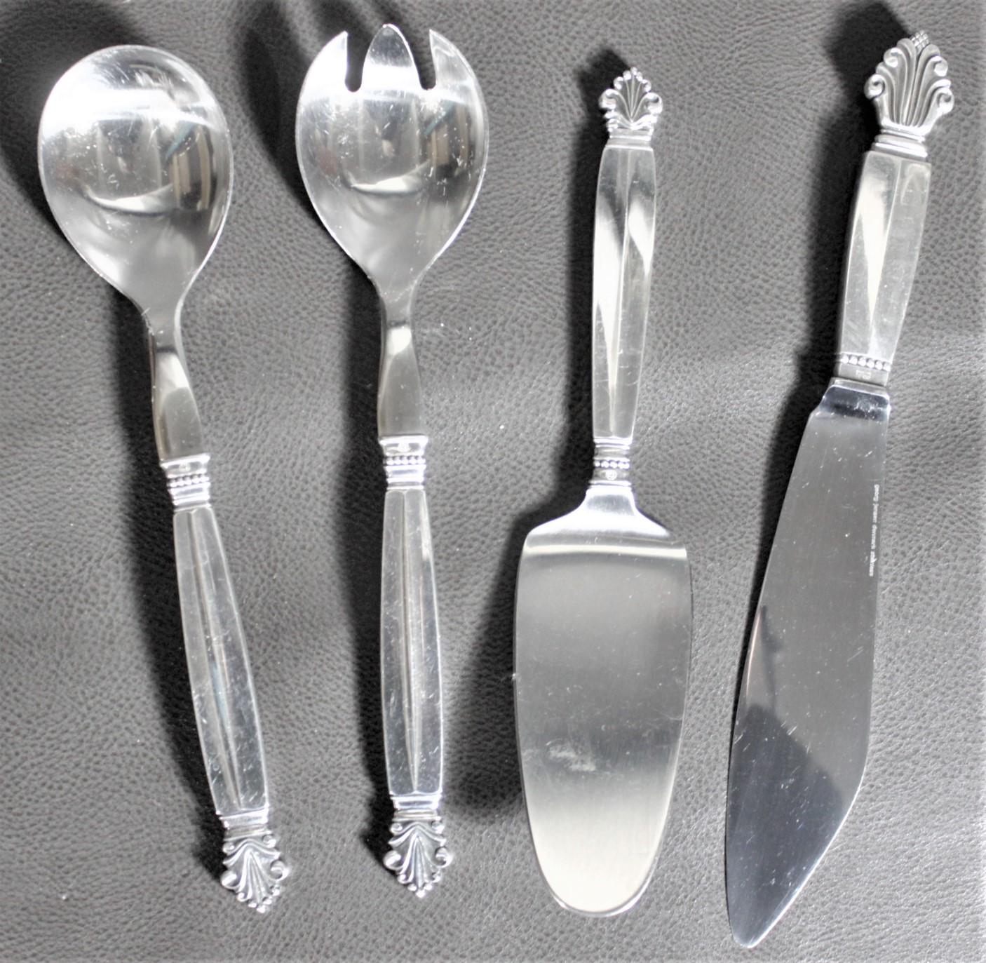 This set of four sterling silver serving pieces was made by the renowned Danish silversmith, Georg Jensen in circa 1960 in his Art Deco styled Acanthus pattern. This grouping includes a cake server and knife and two salad servers.