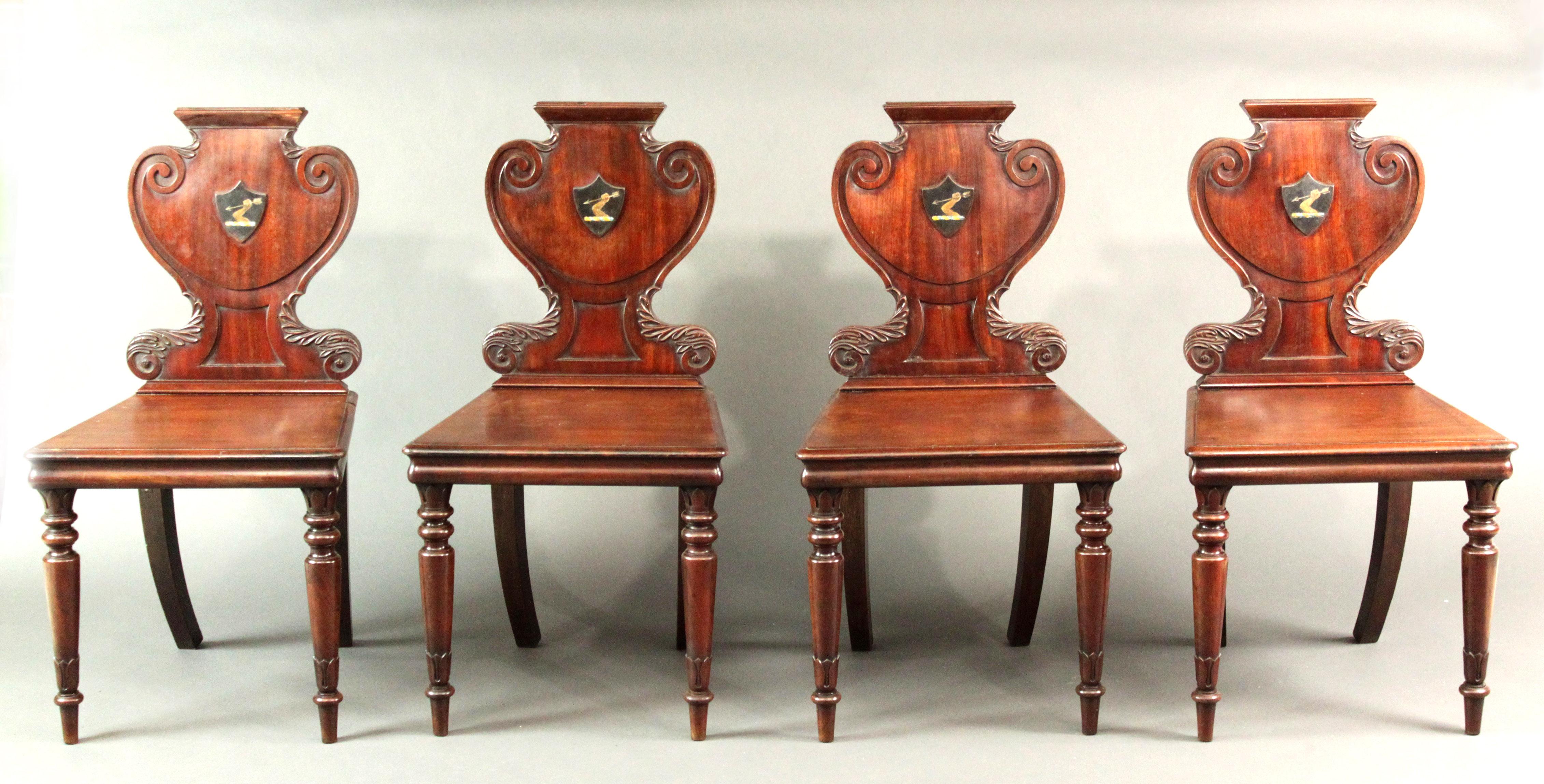 A good set of Regency hall chairs by Williams & Gibton of Dublin, in mahogany of the original color and patina, well carved backs and turned front legs.
The armorial is of an unclothed arm holding aloft an arrow and has a blue and yellow twisted