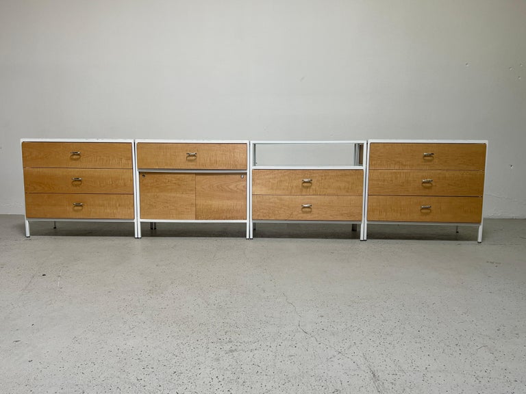A beautiful set of four steel frame cabinets designed by George Nelson for Herman Miller. All cabinets restored with maple drawer fronts and marble tops.