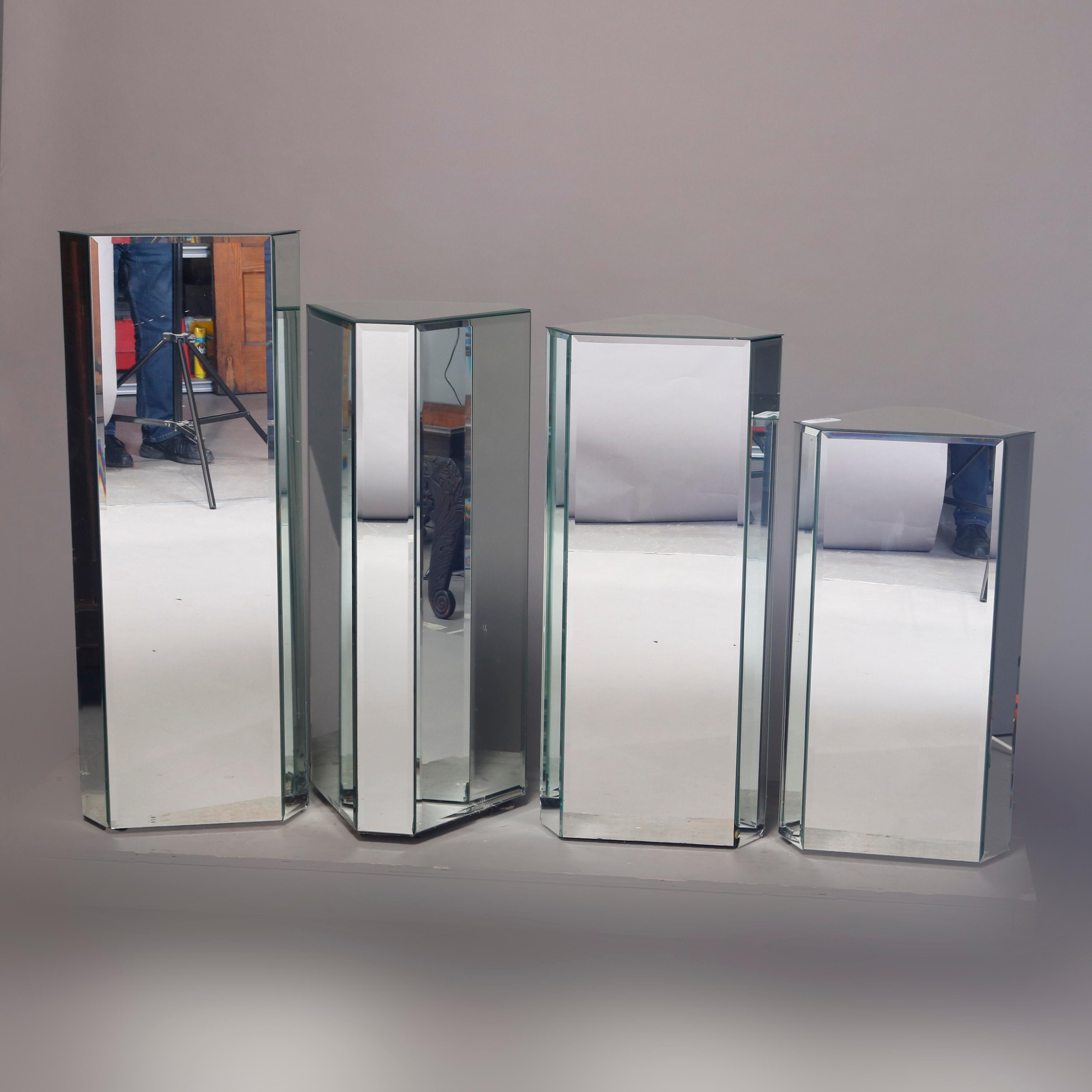 A set of four graduated Mid-Century Modern plant stands offer faceted form with mirrored sides, circa 1960

Measures: 29.25
