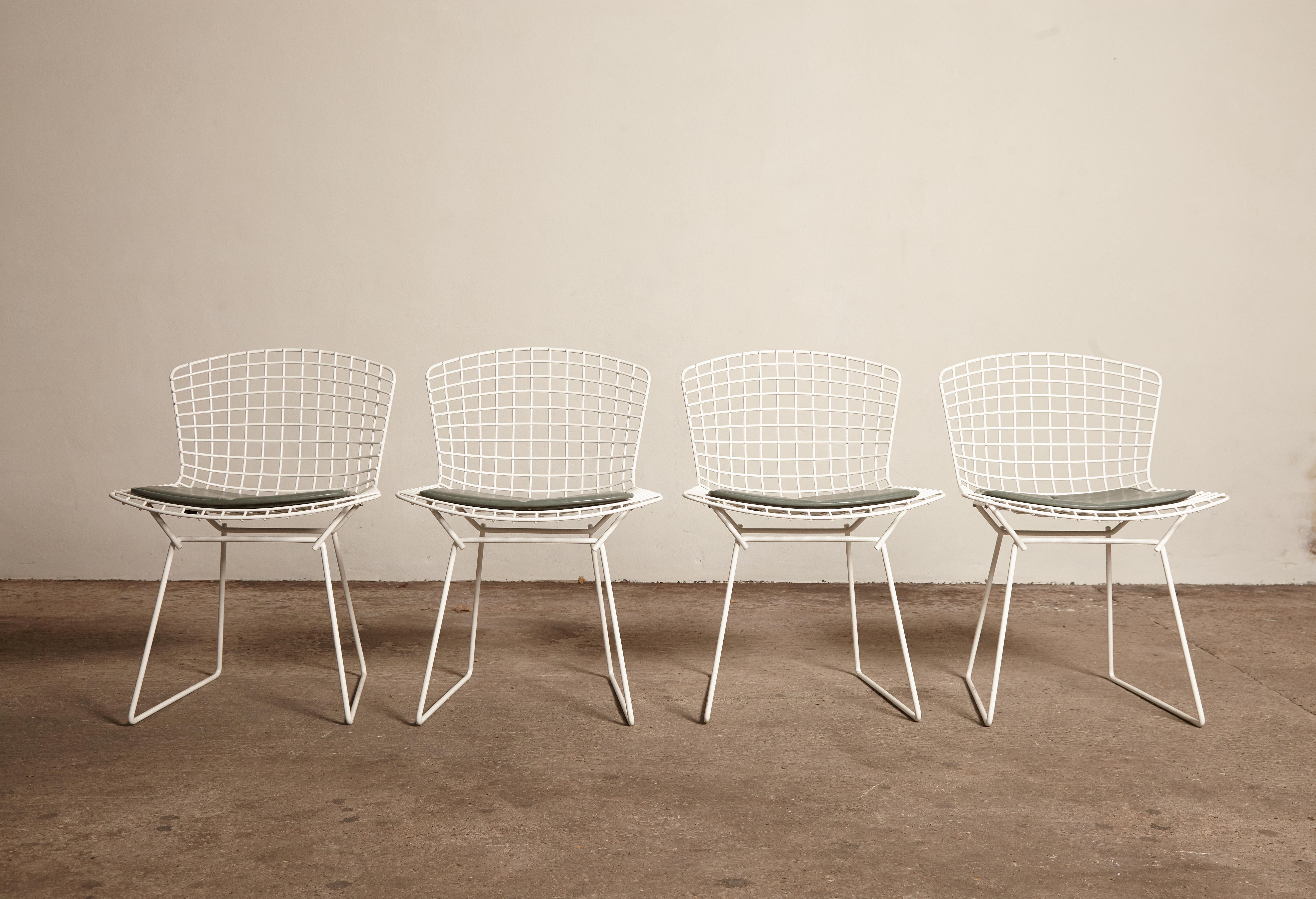 A set of four original Harry Bertoia for Knoll white wire chairs with original green seat pads, USA, 1960s.  Ships worldwide - please contact us directly for a quote.
