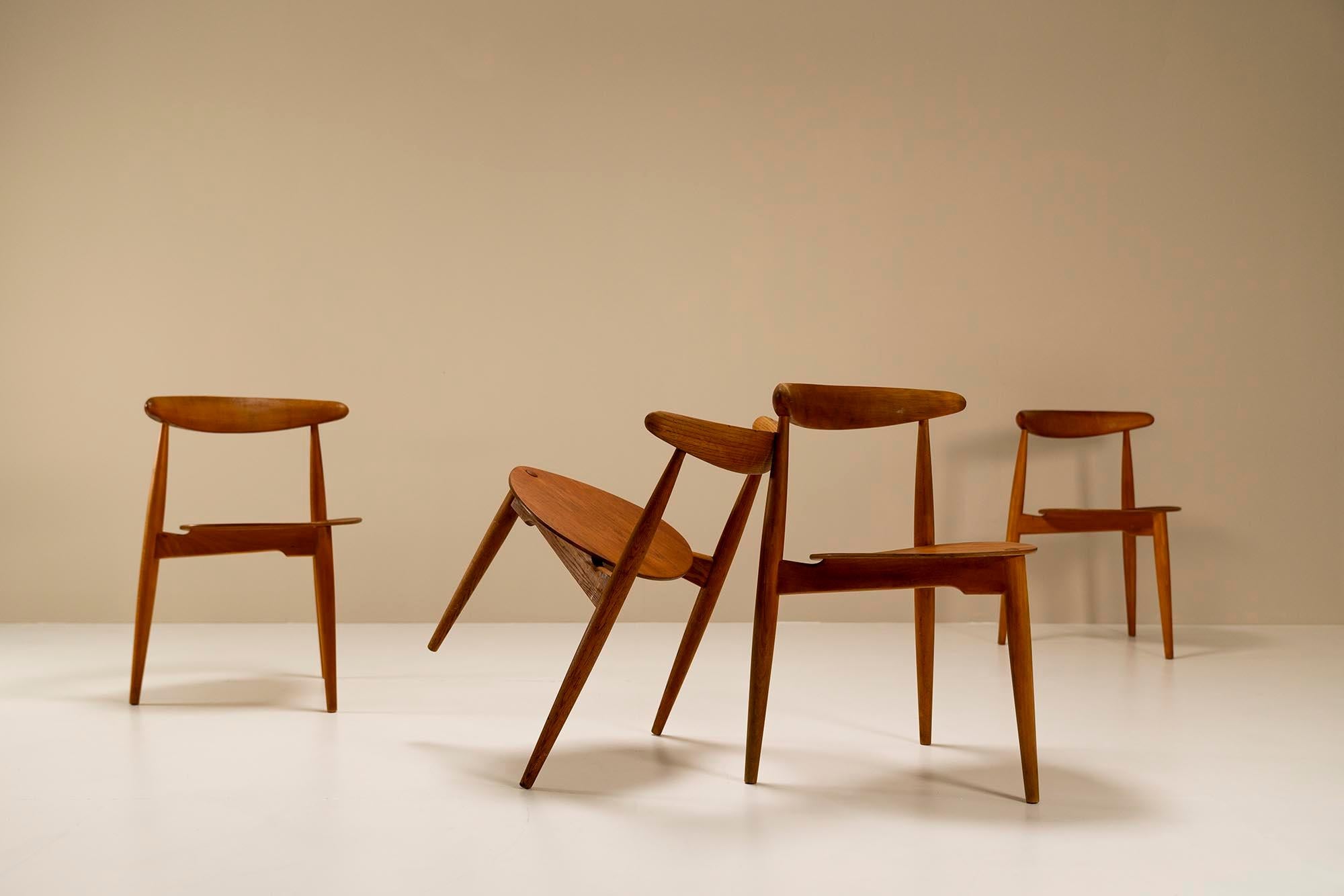 Beautiful set of four 'Heart' dining chairs by Hans Wegner, model FH4103. These are designed in 1953 and manufactured by Fritz Hansen. The chairs have three legs and a 'heart-shaped' seating area. They can be stacked and are practical around a