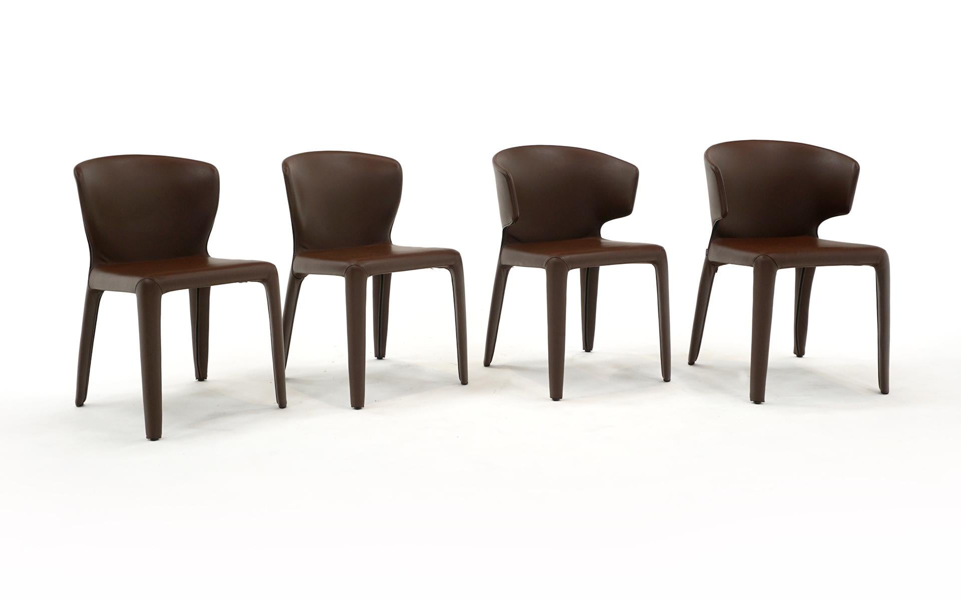 Set of four Hola dining chairs in dark brown leather designed by Hannes Wettstein. An internal steel structure is padded with cfc-free polyurethane foam. The frame is completely covered in leather (cover removable). Feet made of black plastic. These