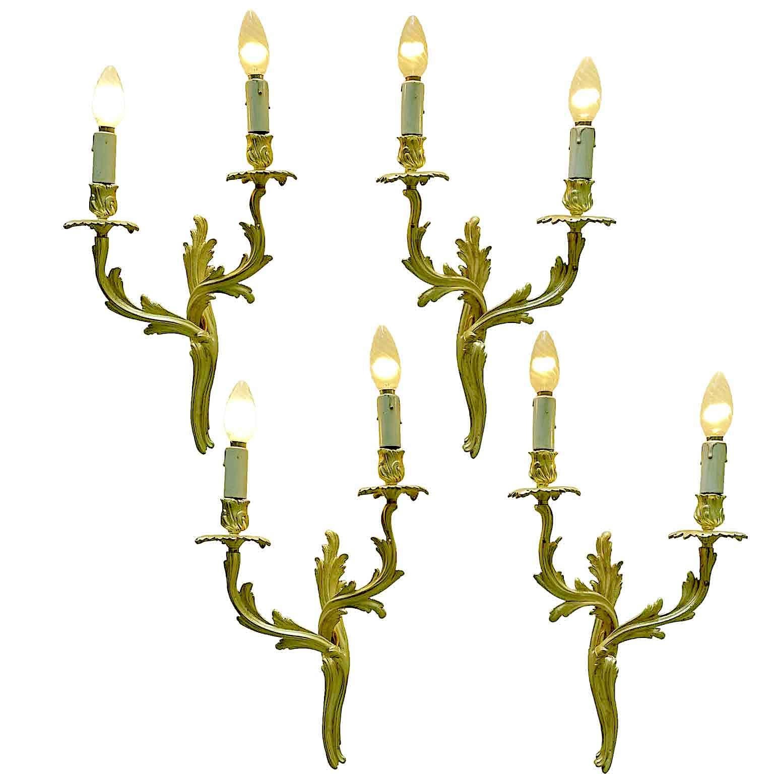 A set of Four Italian Gilt Bronze Sconces Louis XV Style, scrolling curved line two-armed wall lights dating back to the first half of 20th century 1950s circa. A set of four gilded twin arm wall lights in the Louis XV taste of stylized rococo