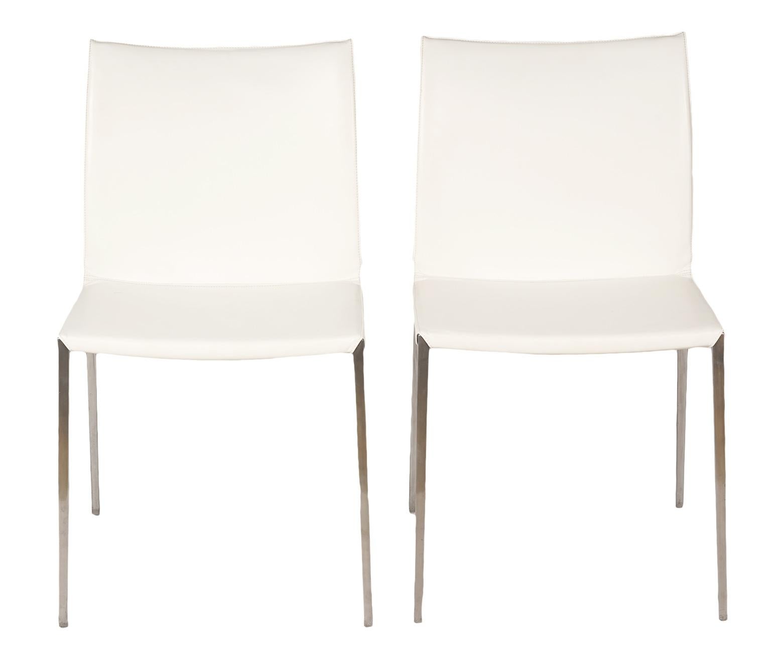 These contemporary 'Lia' white leather side chairs by Roberto Barbieri were presented by Zanotta in 1999. The chair proved to be innovative due to the increasingly advanced use of die-casting: the chair side is made of one single element in aluminum