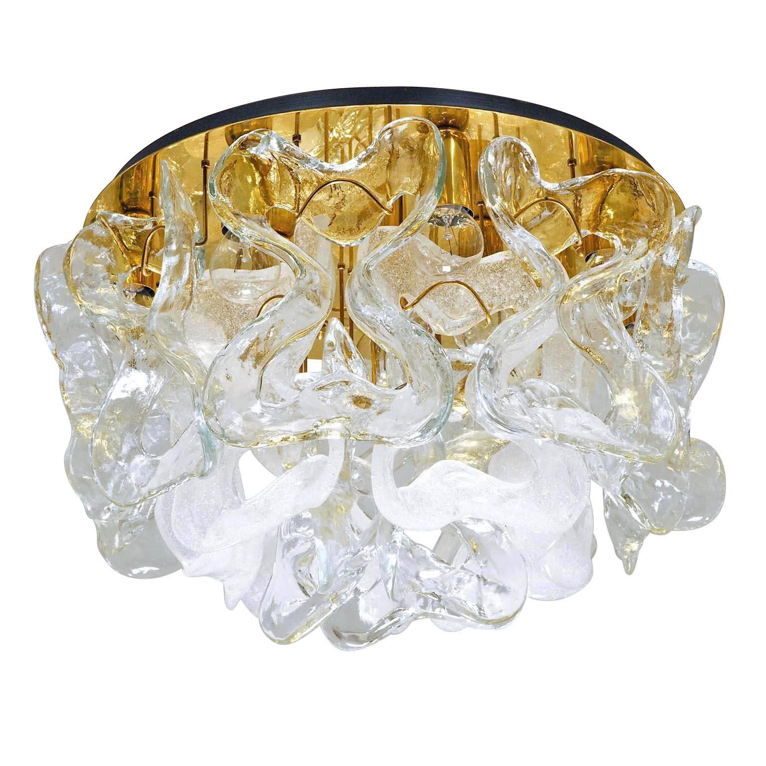 One of four gorgeous flush mounts model 'Catena' by Kalmar, Vienna, Austria, manufactured in midcentury, circa 1970 (late 1960s or 1970s).
18 large 'ribbons' in clear (12 pieces) and white bubble Murano glass (6 pieces) hang on a polished brass