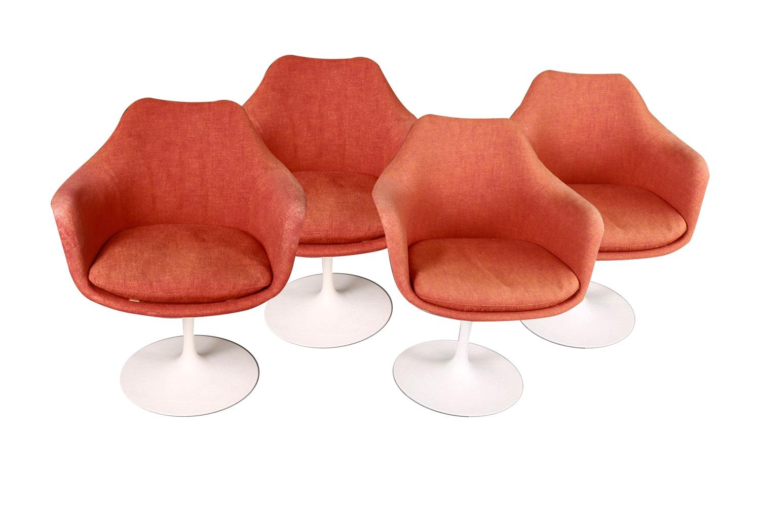 Classic mid-century modern set of four tulip swivel, armchairs, side, dining chairs, for Knoll designed by Eero Saarinen (USA). Features molded white lacquered fiberglass form resting on cast aluminum swivel base with original knoll removable seat