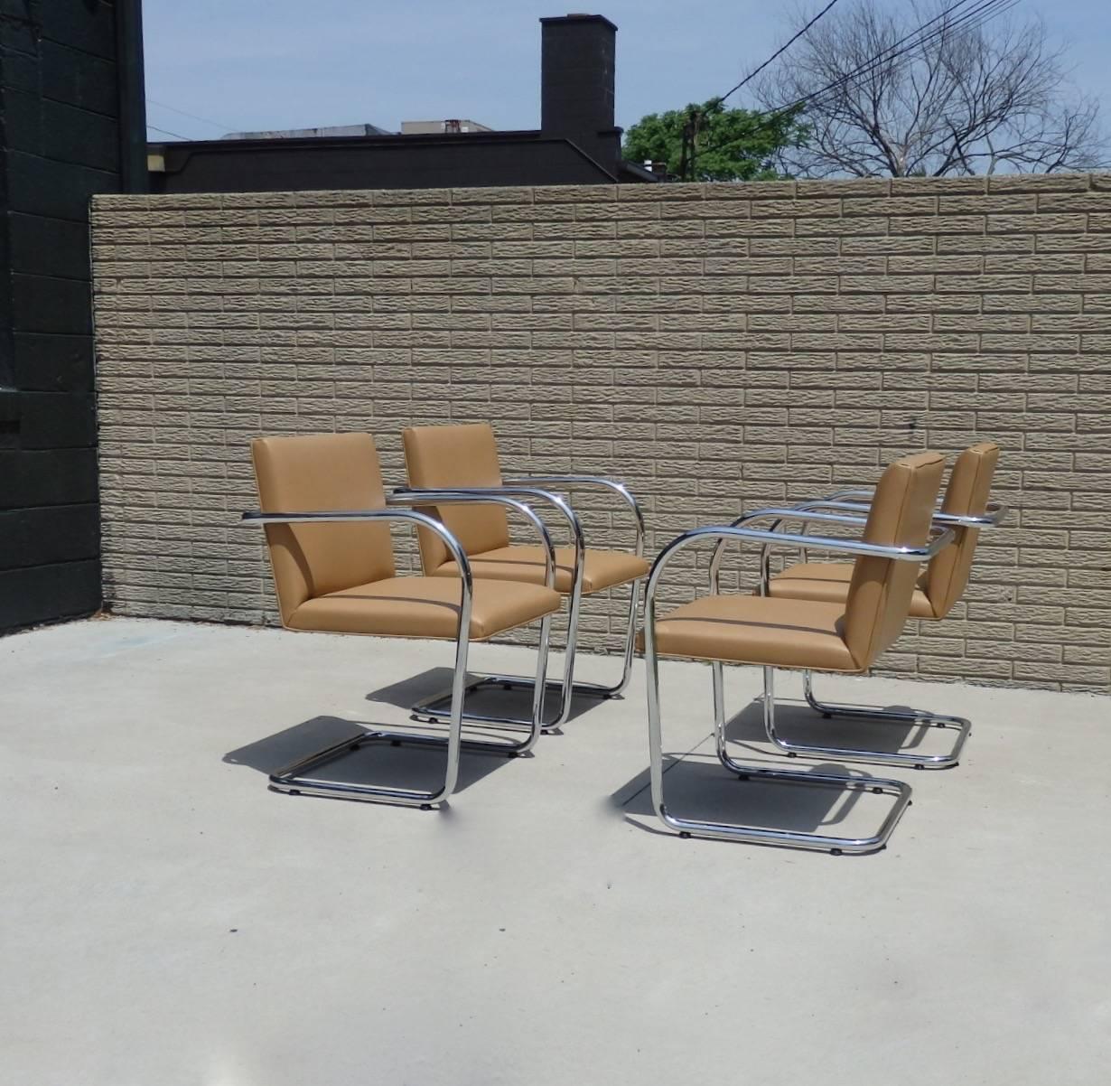 Immaculate set of four Brno chairs. Designed by Mies van der Rohe licensed to Knoll. Signature etched in the arms. Retains paper label underneath. Tubular chrome frames are excellent as is the coffee brown supple Naugahyde.