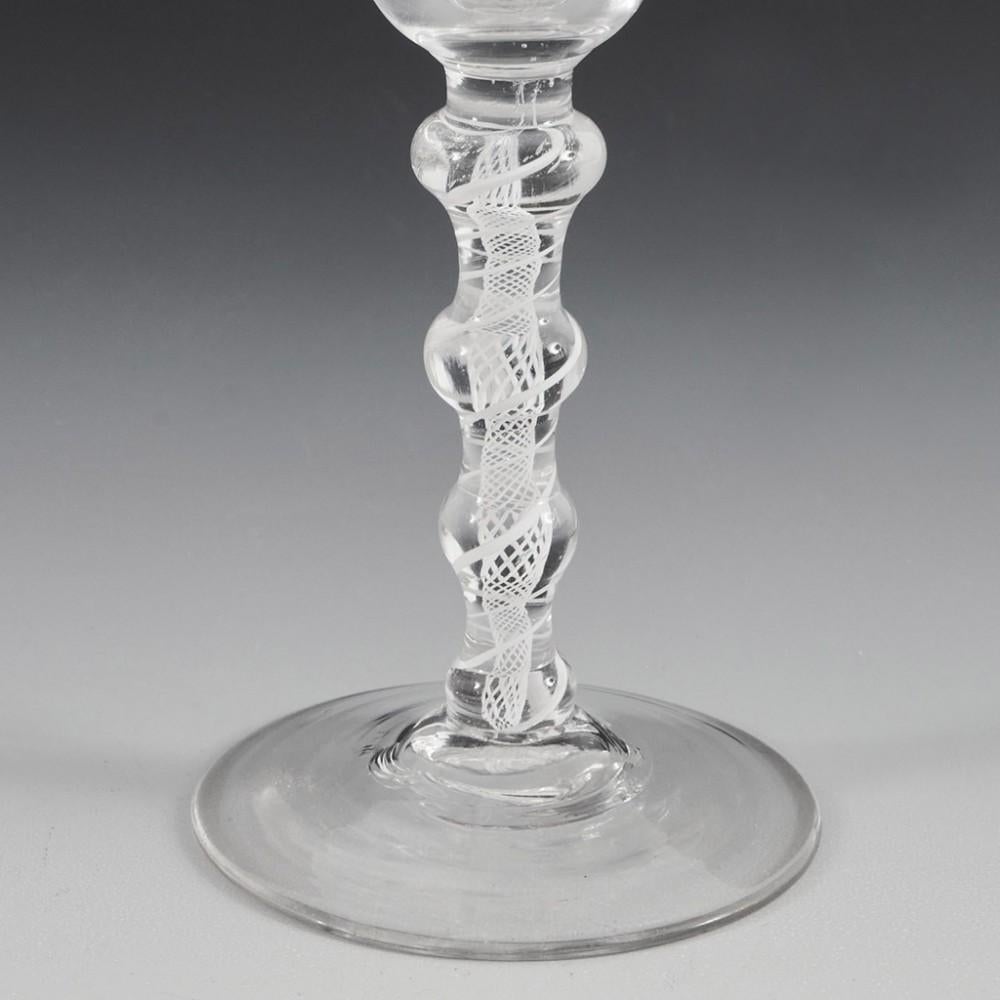 Heading : Four knop double series opaque twist wine glass
Period : George II / George III - c1760
Origin : England
Colour : Clear
Bowl : Bell
Stem : Inverted baluster knop, flattened ball, ball, and cushion. A pair of spiral tapes otuwith a spiral